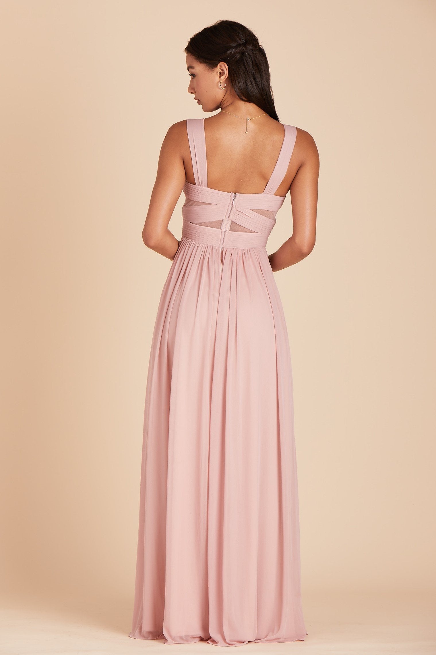 Back view of the Elsye Bridesmaid Dress in dusty rose mesh reveals a square cut just below the shoulder blades and the pleated column skirt gracefully flowing to the floor.