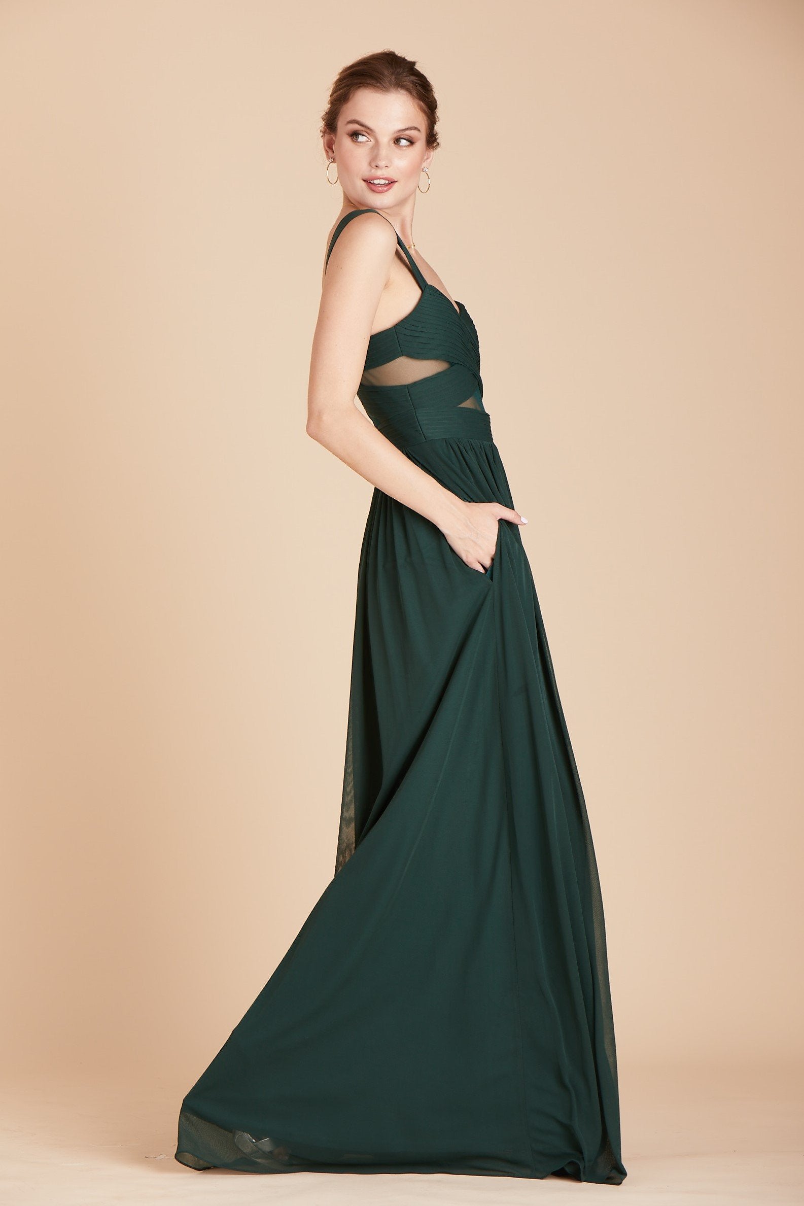 Elsye bridesmaid dress in emerald green chiffon by Birdy Grey, side view with hand in pocket