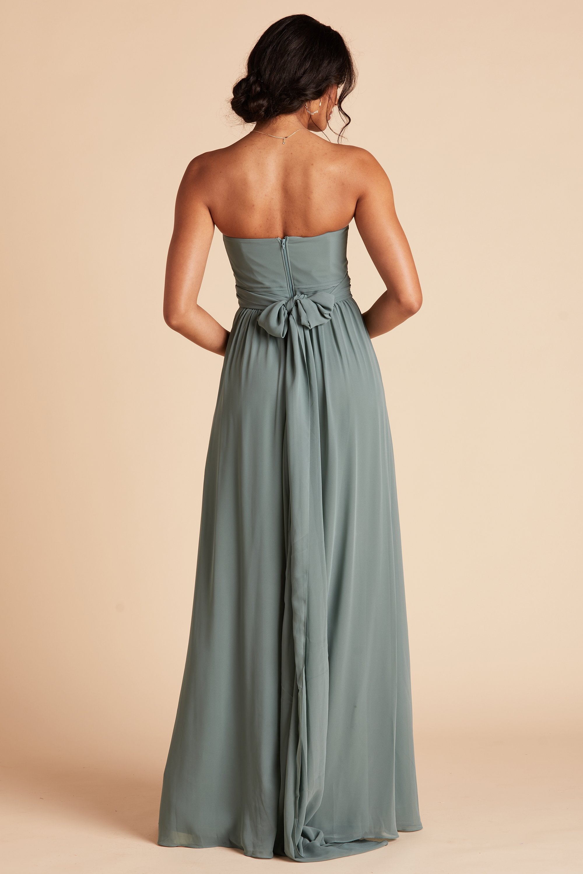 Back view of the Grace Convertible Bridesmaid Dress in sea glass chiffon reveals an open back cut below the shoulder blades with front streamers tied around the waist in a delicate and flowing bow.