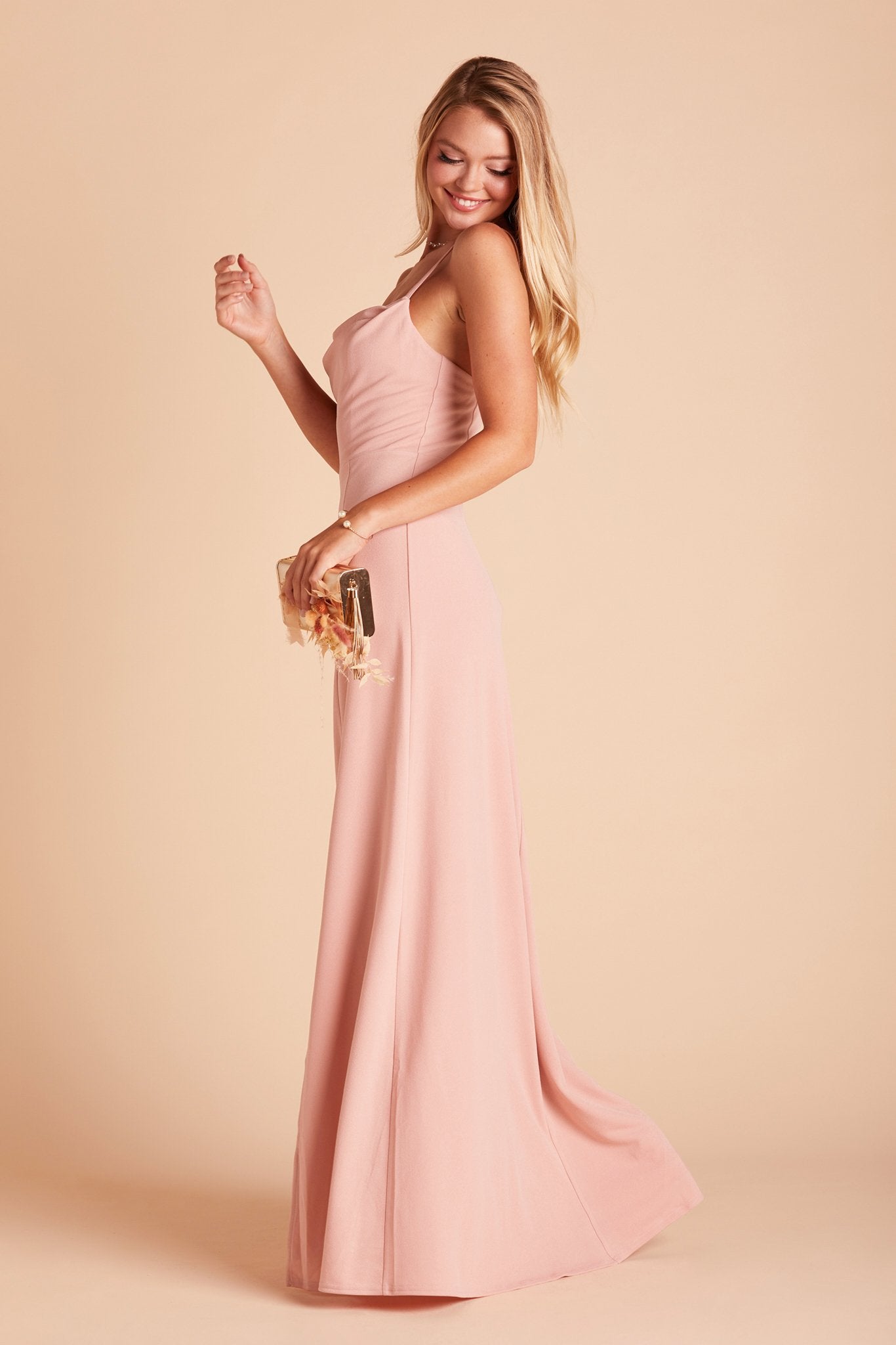 Side view of the Ash Bridesmaid Dress in dusty rose crepe shows a fitted bust and waist with a delicate flowing skirt.
