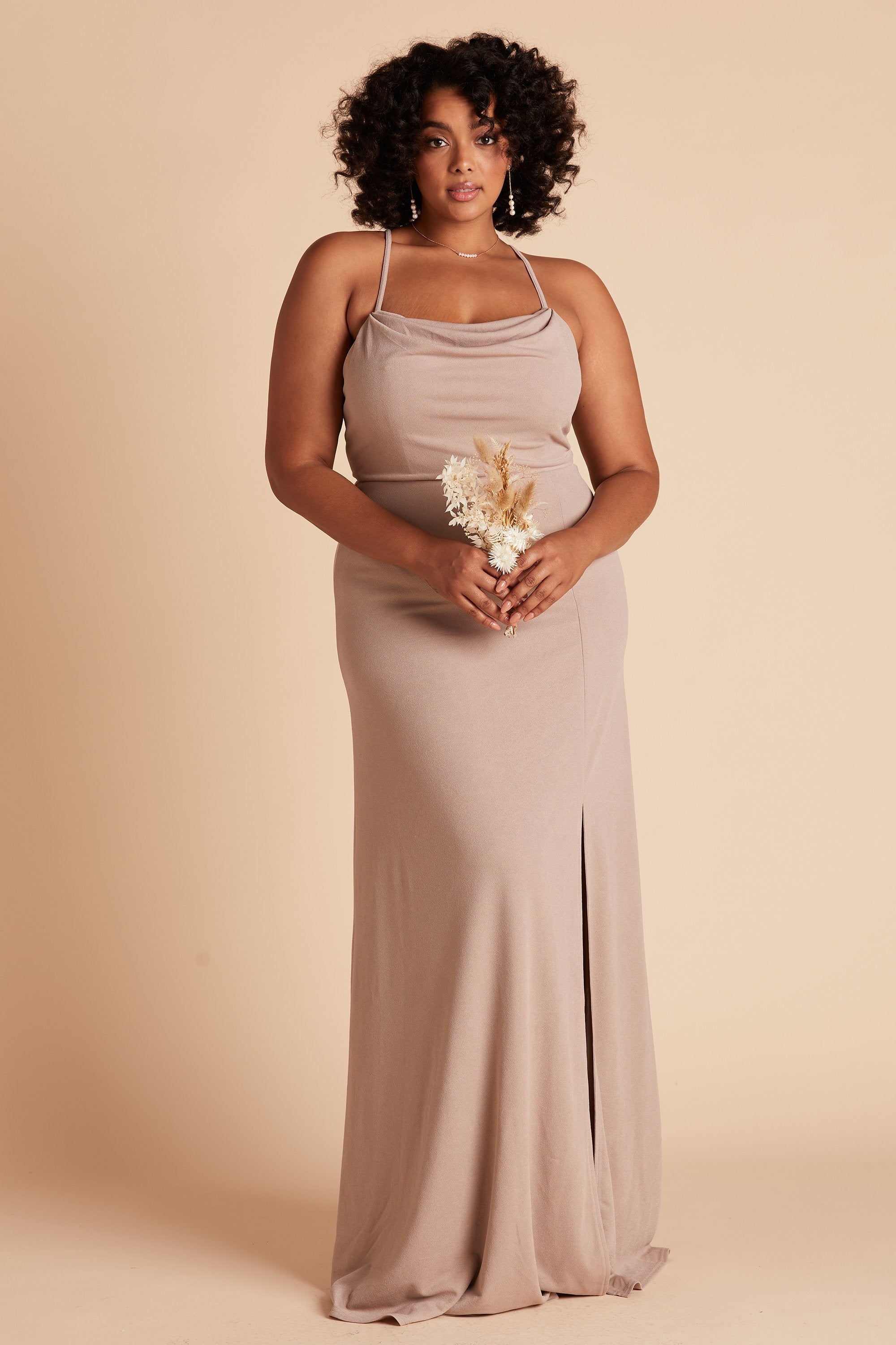 Front view of the floor-length Ash Plus Size Bridesmaid Dress in taupe crepe by Birdy Grey with a slightly draped cowl neck front. The flowing skirt features a slit over the front left leg.