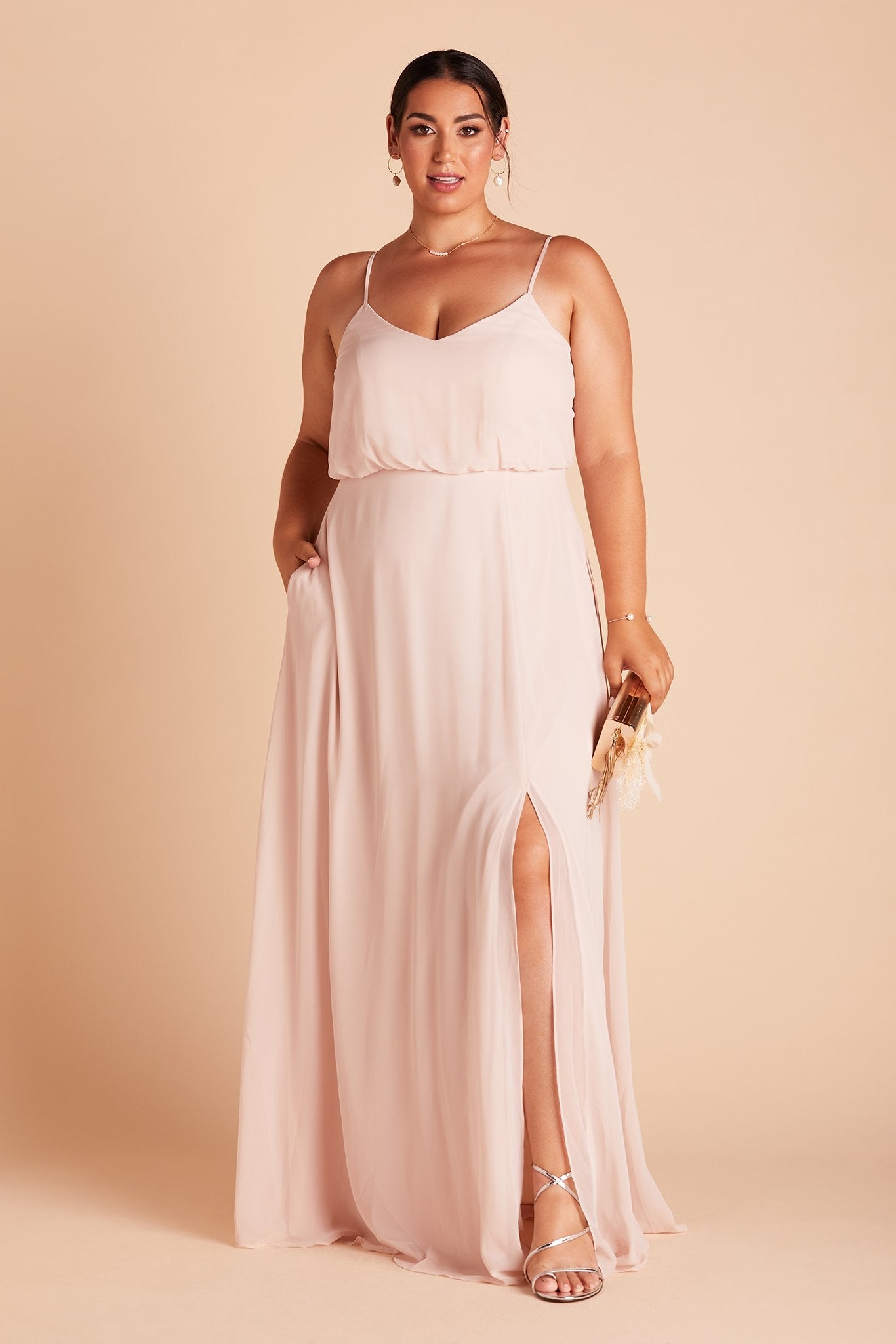 Gwennie plus size bridesmaid dress with slit in pale blush chiffon by Birdy Grey, front view with hand in pocket