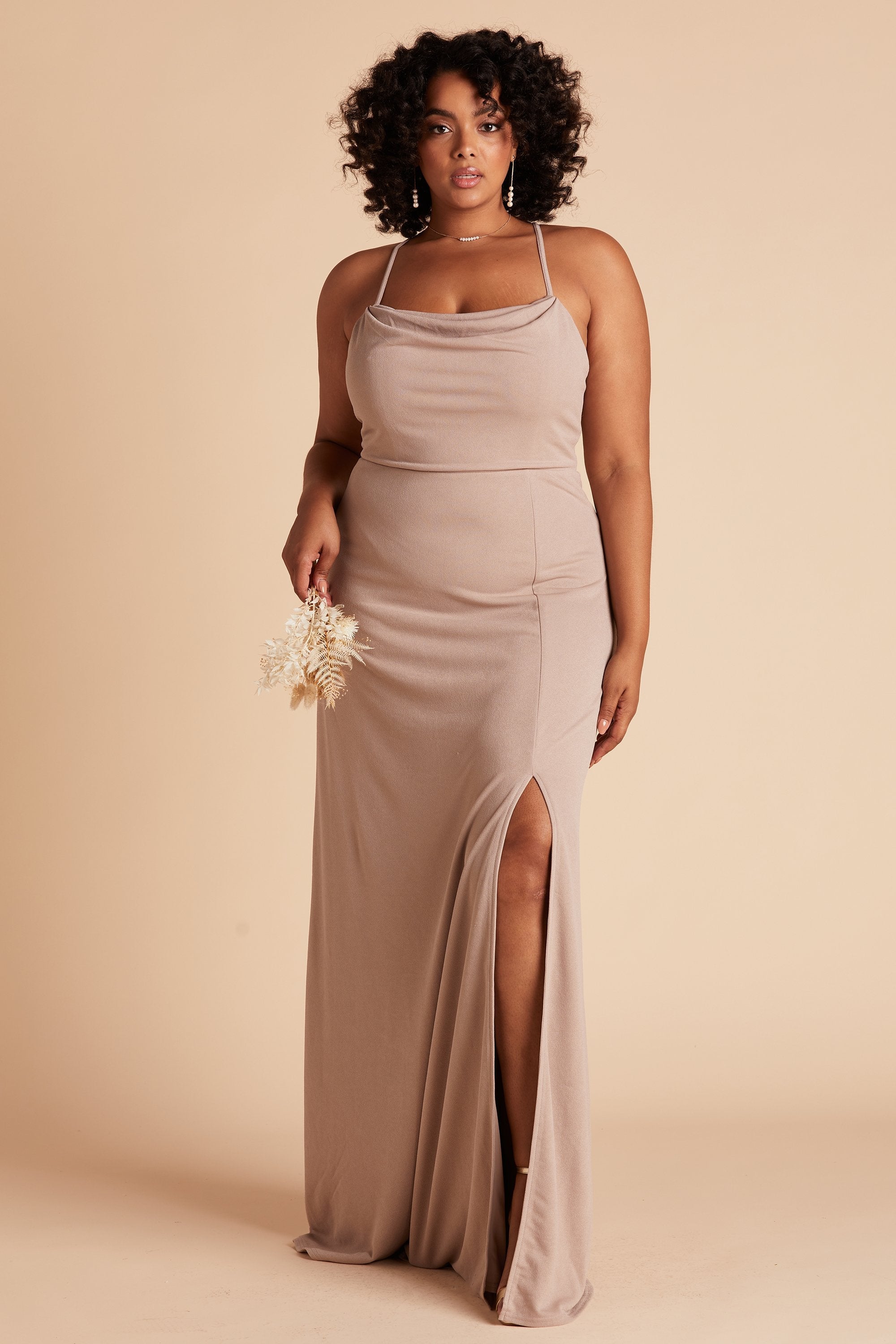 Front view of the floor-length Ash Plus Size Bridesmaid Dress in taupe crepe worn by a curvy model with a medium-dark skin tone.