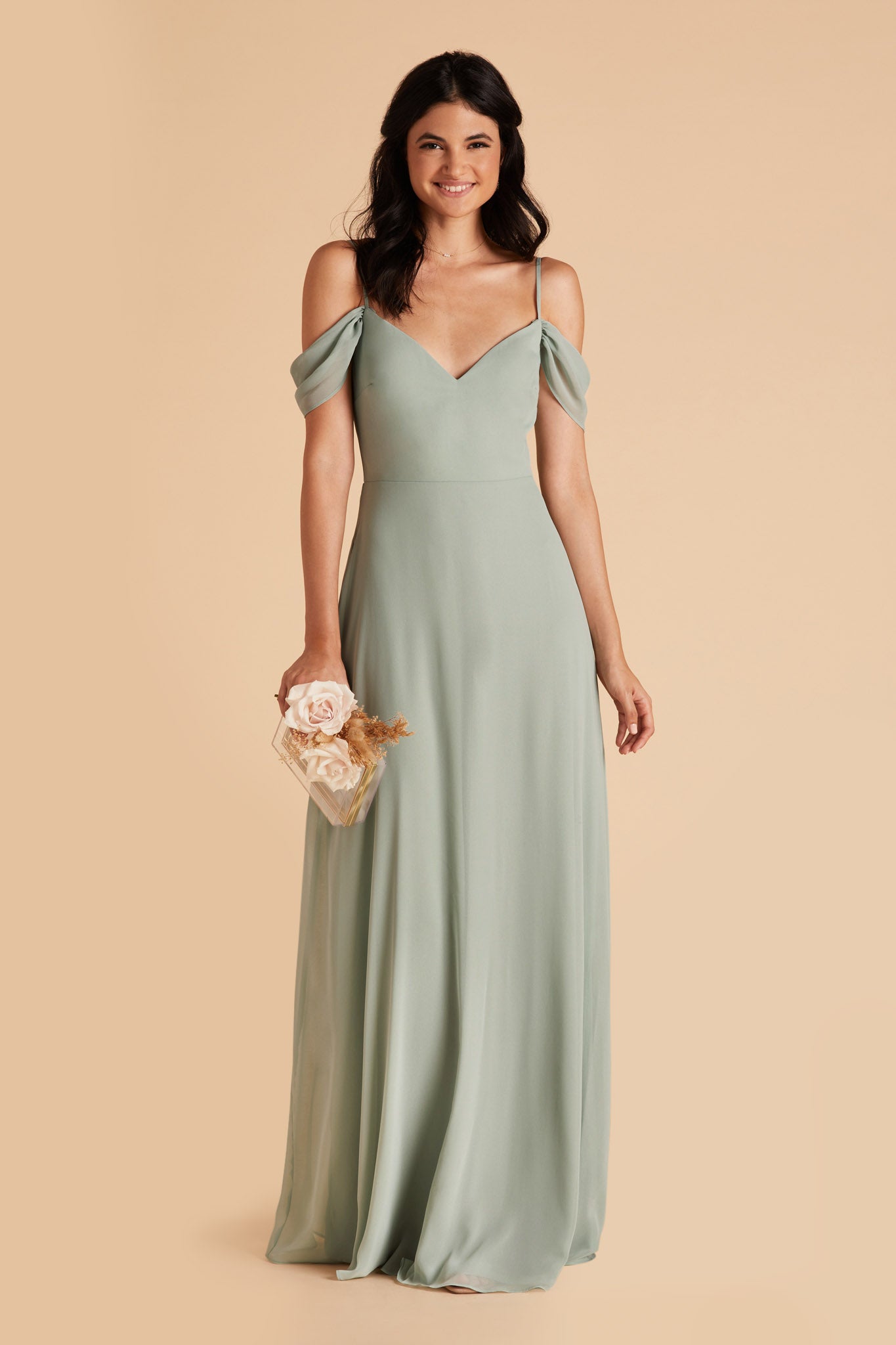Front view of the floor-length Devin Convertible Bridesmaid Dress in sage chiffon worn by a slender model with a medium skin tone. The dress detachable sleeves drape gracefully over the model’s upper arms.