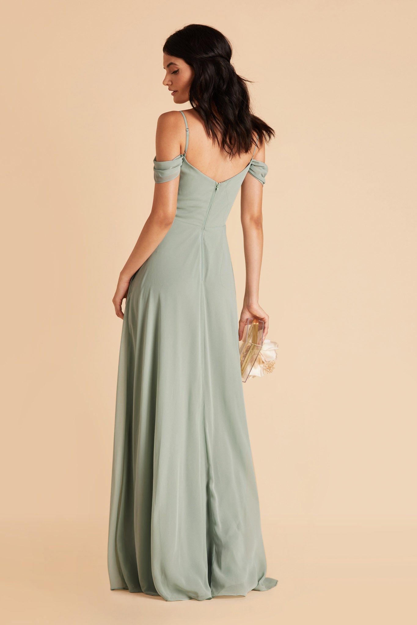 Back view of the floor-length Devin Convertible Bridesmaid Dress in sage chiffon displays adjustable spaghetti straps and draping sleeves over the upper arms.