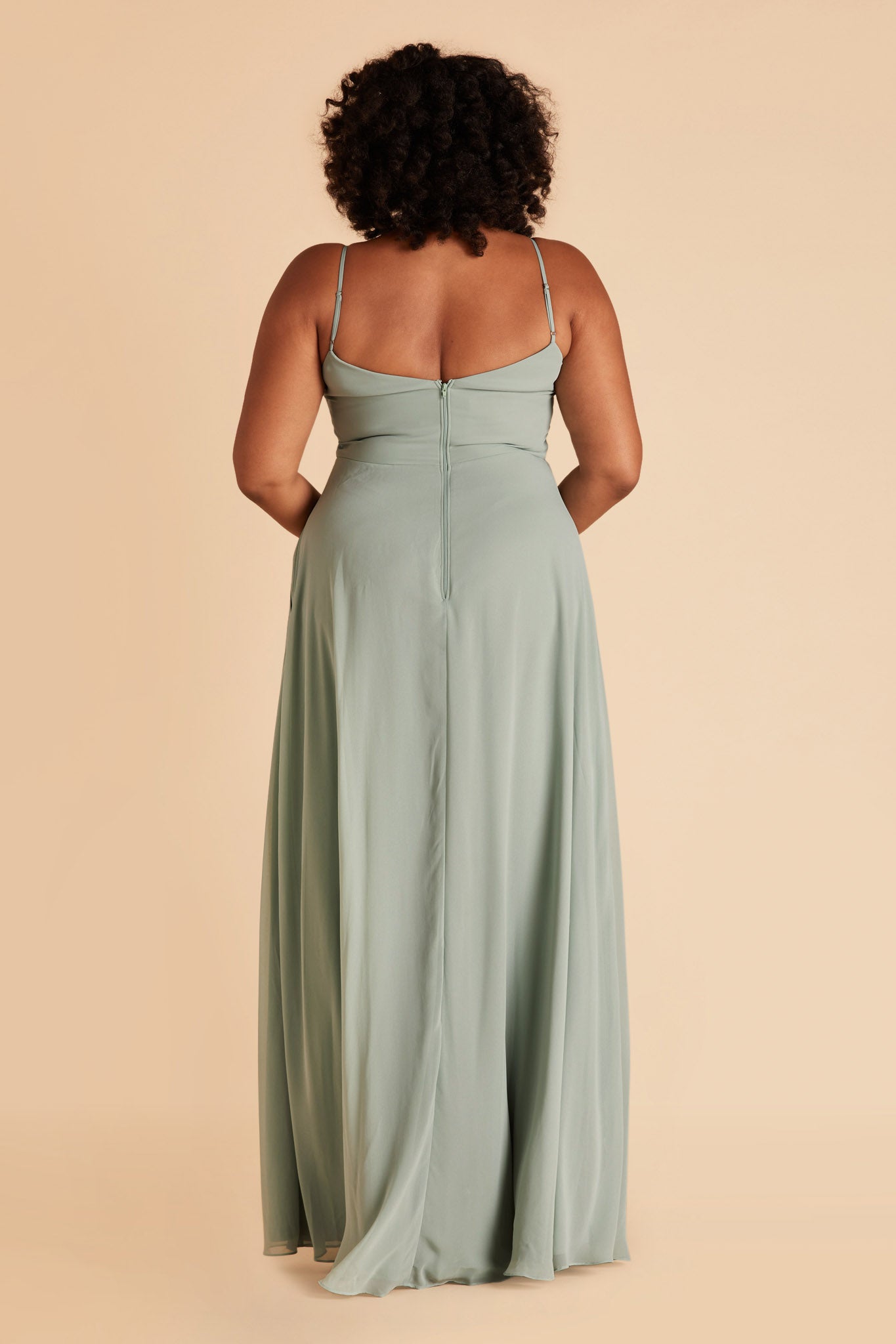 Back view of the floor-length Devin Convertible Plus Size Bridesmaid Dress in sage chiffon displays adjustable spaghetti straps and an open back with a slight v-cut just below the shoulder blades.
