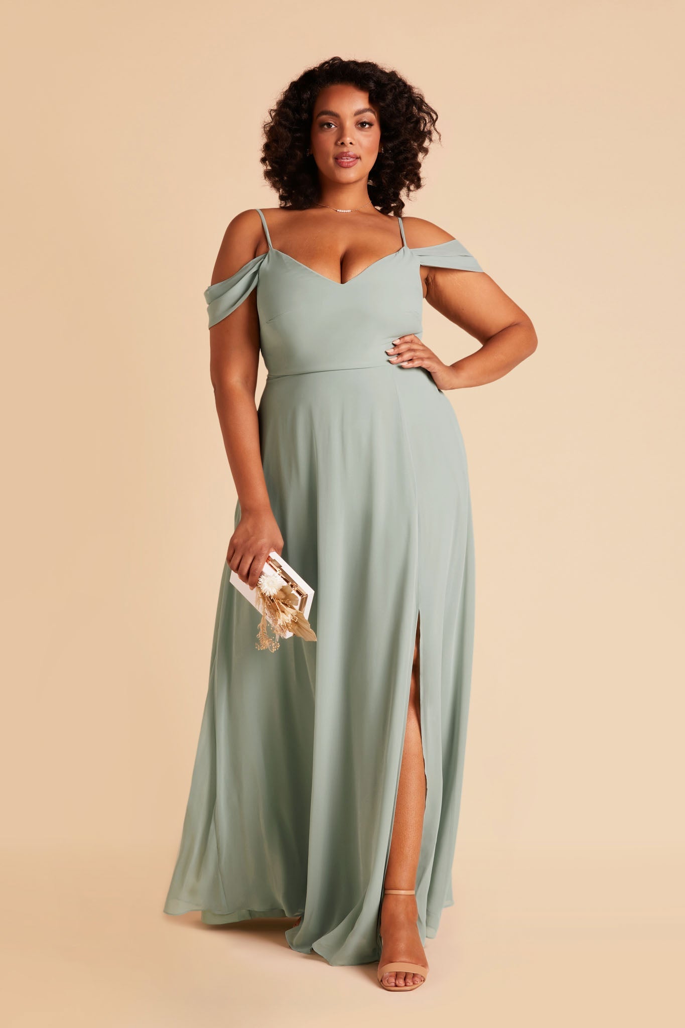 Front view of the floor-length Devin Convertible Plus Size Bridesmaid Dress in sage chiffon by Birdy Grey with a V-neck front and draping detachable sleeves. The dress features an optional slit over the left front leg.