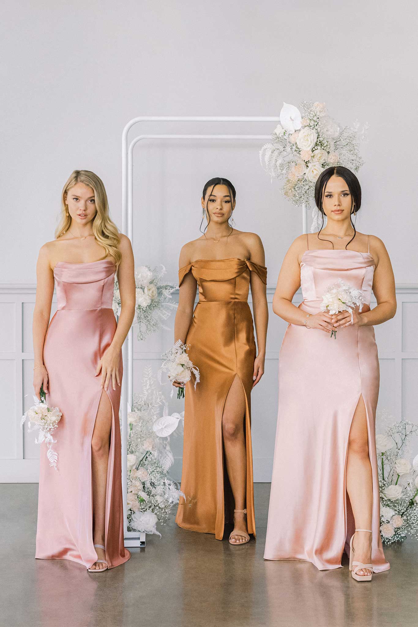 Three long satin bridesmaid dresses in pink, brown, light pink satin with pleated cowl neck