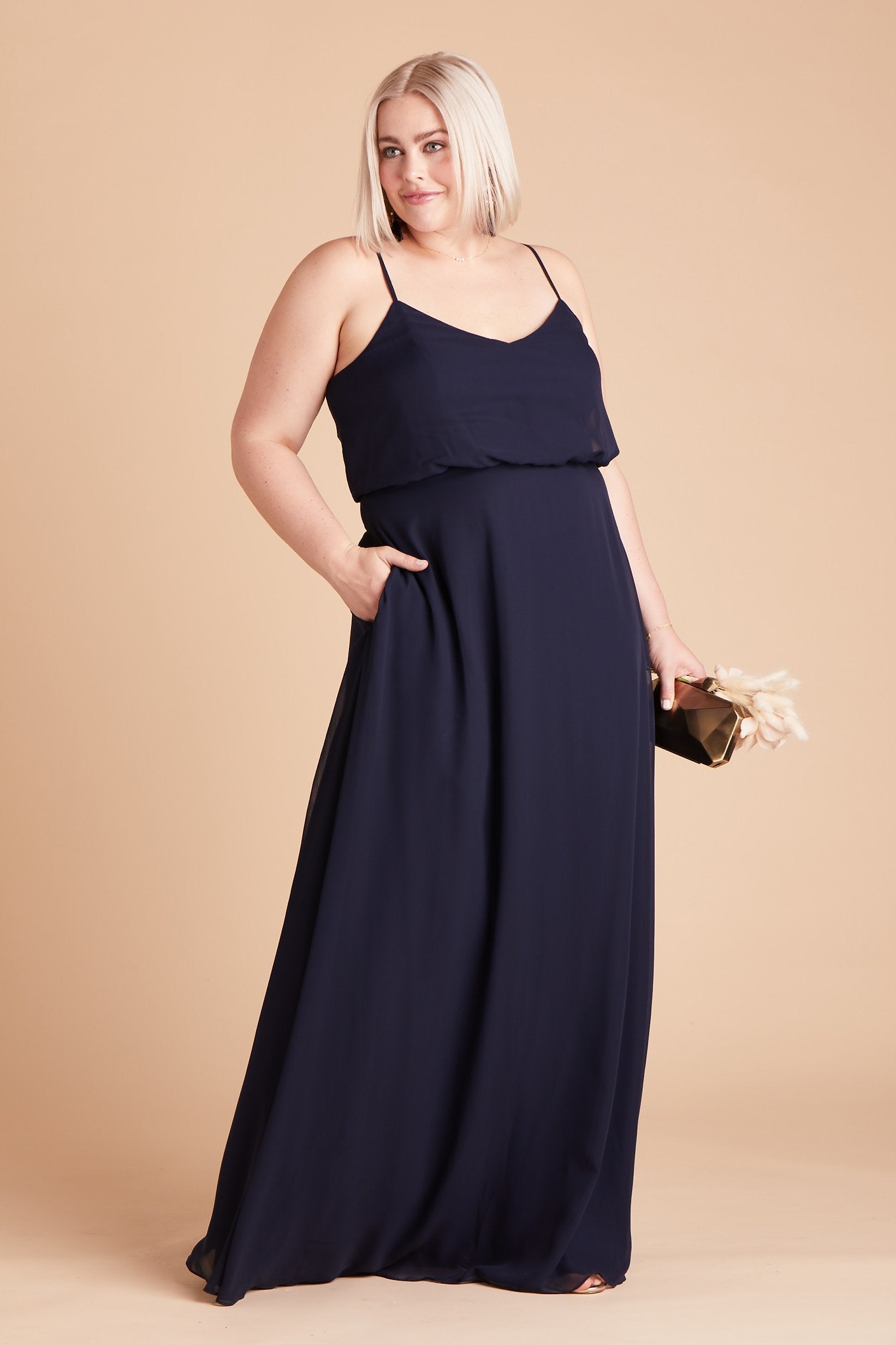 Gwennie plus size bridesmaid dress in navy blue chiffon by Birdy Grey, front view with hand in pocket