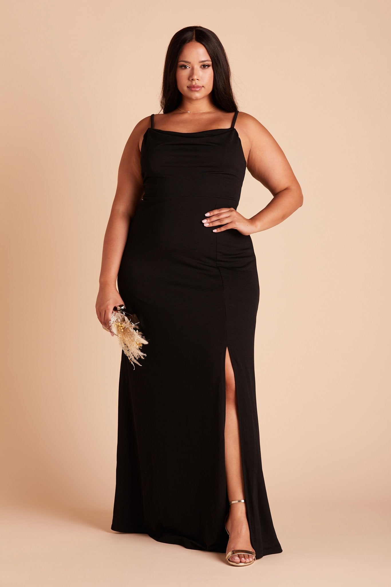 Front view of the floor-length Ash Bridesmaid Dress Curve in black crepe by Birdy Grey with a slightly draped cowl neck front. The flowing skirt features a slit over the front left leg.