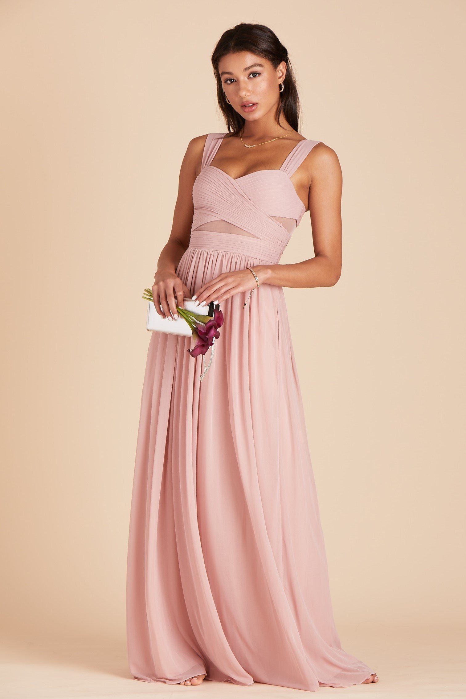 Front view of the Elsye Bridesmaid Dress in dusty rose mesh features a fitted bust and waist with peekaboo cutouts showing a hint of skin at the waist and under each arm.