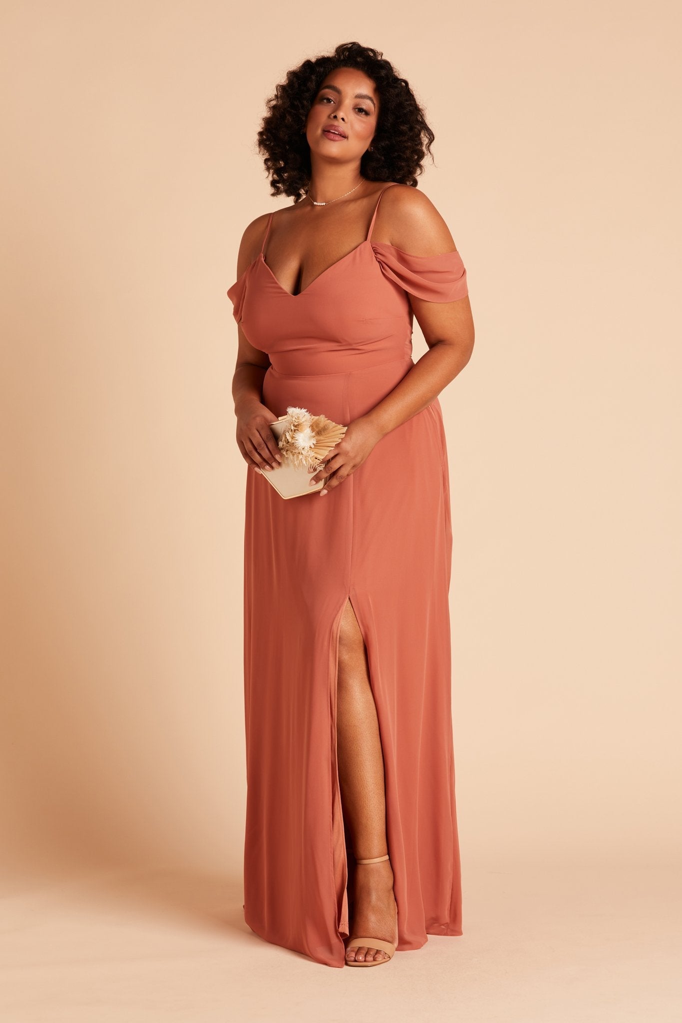 Front view of the floor-length Devin Convertible Plus Size Bridesmaid Dress in terracotta chiffon worn by a curvy model with a medium skin tone. The dress’s detachable sleeves drape gracefully over the model’s upper arms.