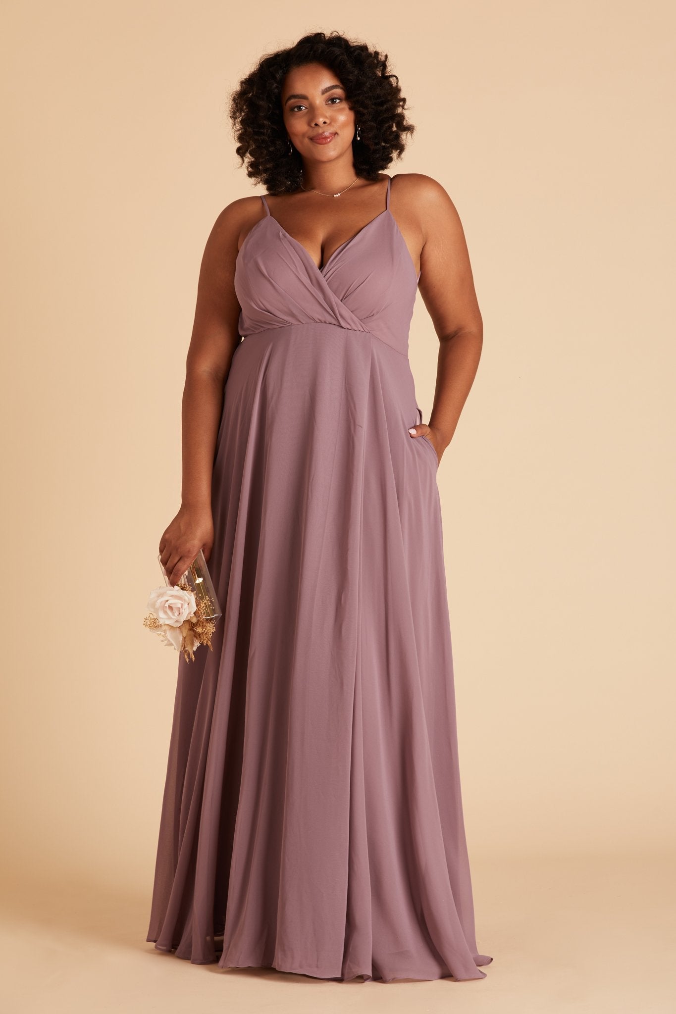 Kaia plus size bridesmaids dress in dark mauve purple chiffon by Birdy Grey, front view with hand in pocket