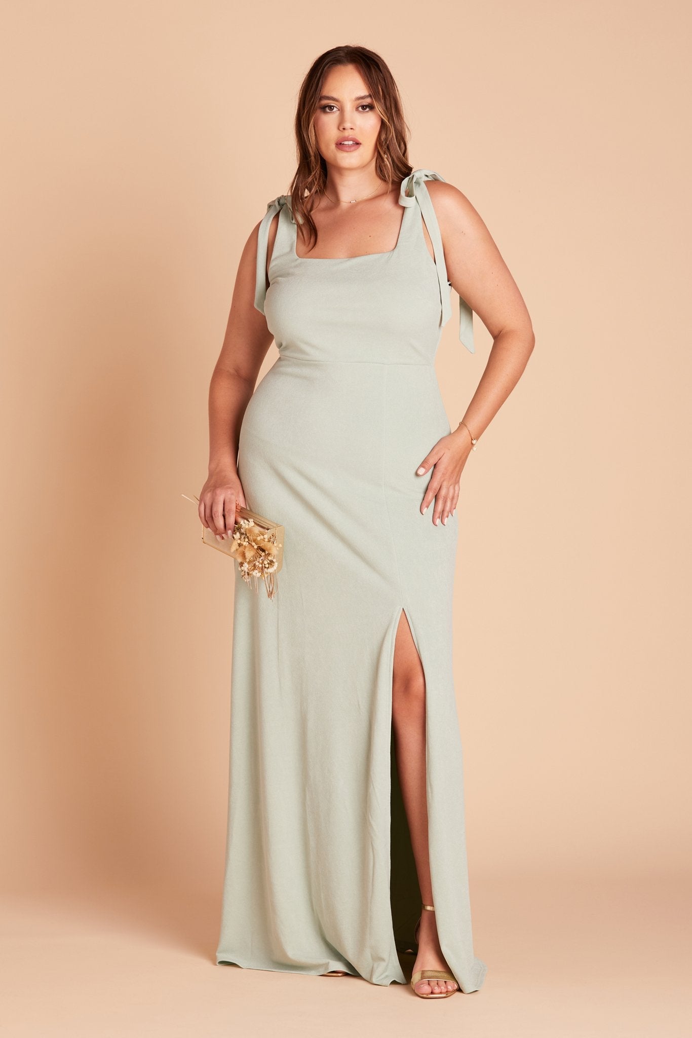 Front view of the Alex Convertible Plus Size Bridesmaid Dress in sage green crepe with shoulder ties that are tied in a bow and draped down over each shoulder.