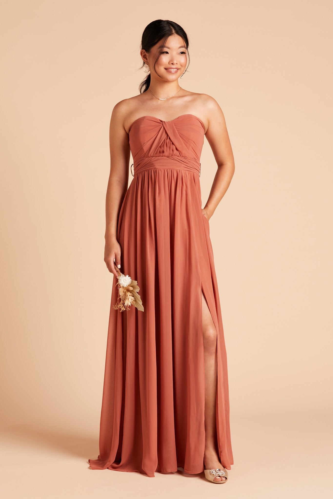 Grace convertible bridesmaid dress in terracotta orange chiffon by Birdy Grey, front view with hand in pocket