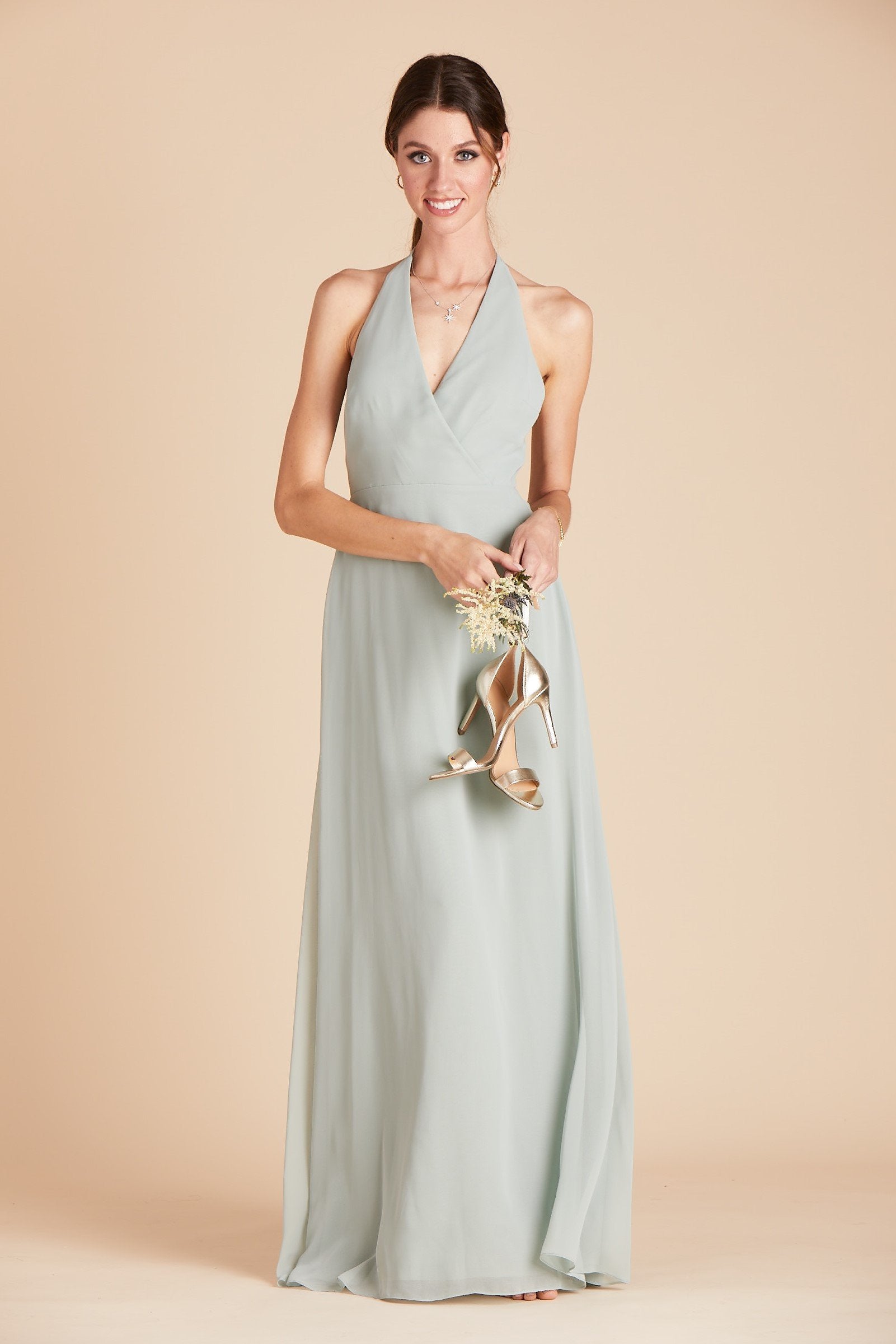 Front view of a floor length dress in sage chiffon worn by a slender model with a light skin tone. 