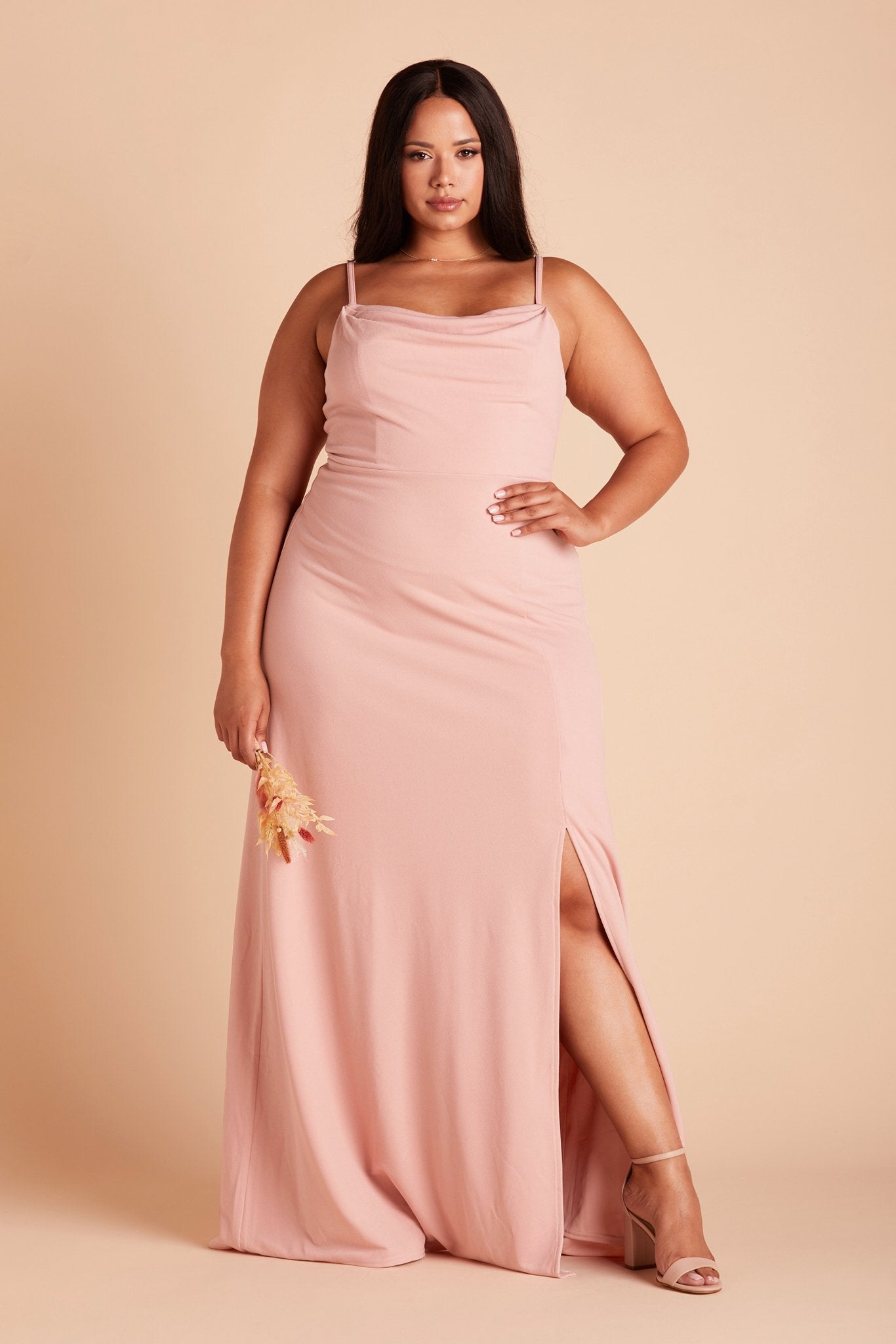 Front view of the floor-length Ash Plus Size Bridesmaid Dress in dusty rose crepe by Birdy Grey with a slightly draped cowl neck front. The flowing skirt features a slit over the front left leg.