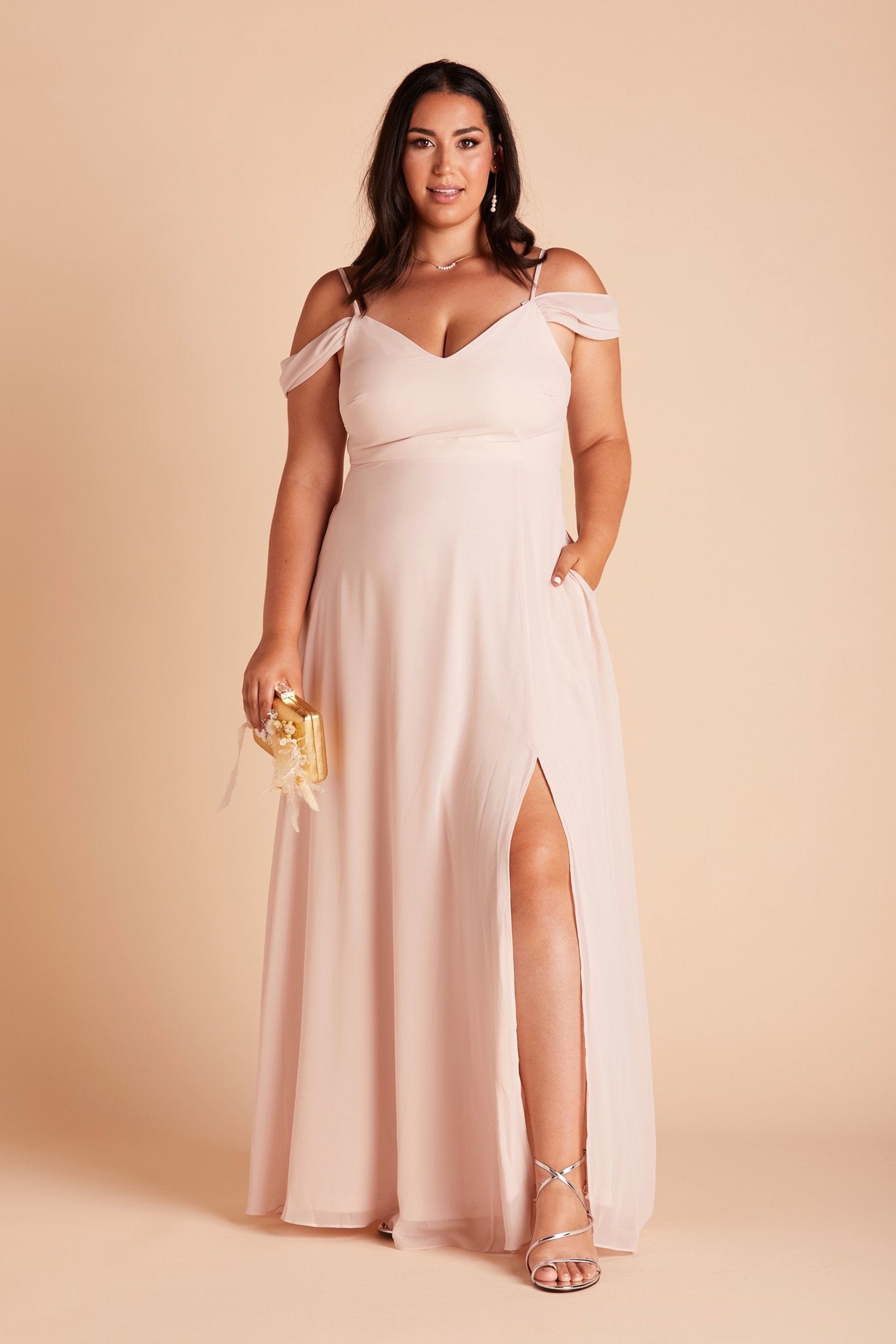 Devin convertible plus size bridesmaids dress with slit in pale blush chiffon by Birdy Grey, front view with hand in pocket