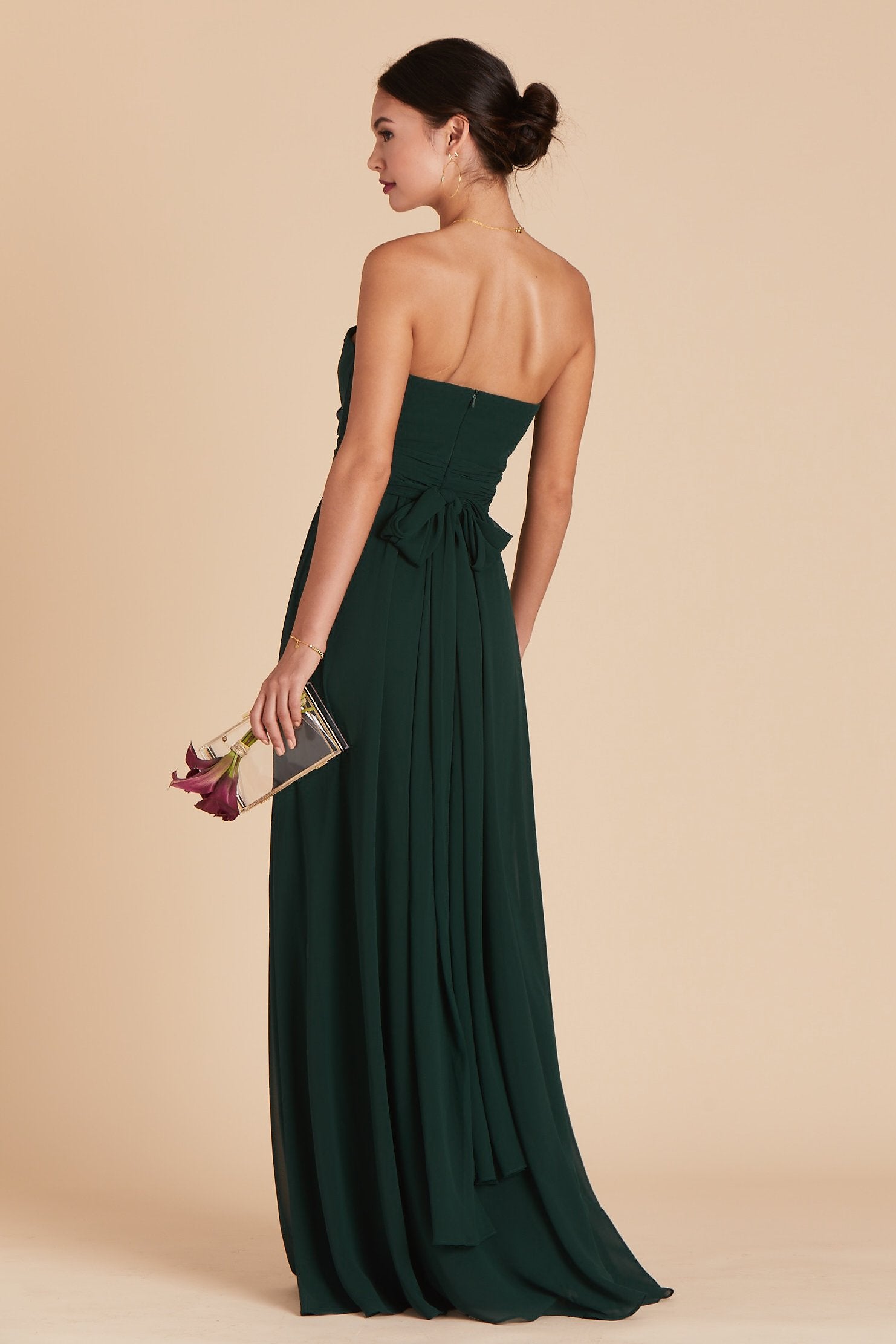 Back view of the Grace Convertible Bridesmaid Dress in emerald chiffon reveals an open back cut below the shoulder blades with front streamers tied around the waist in a delicate and flowing bow.