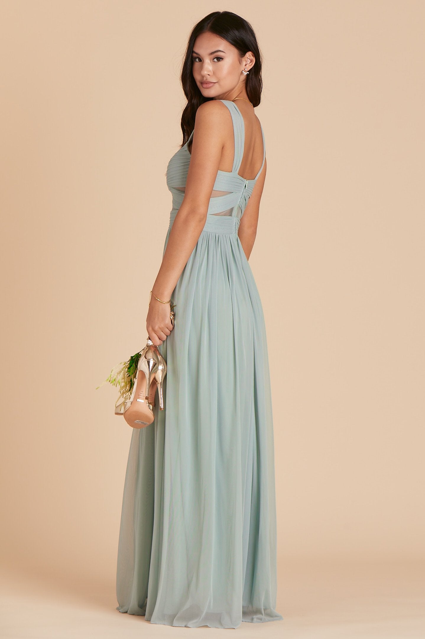 Side view of the Elsye Bridesmaid Dress in sage mesh worn by a slender model with a medium skin tone.