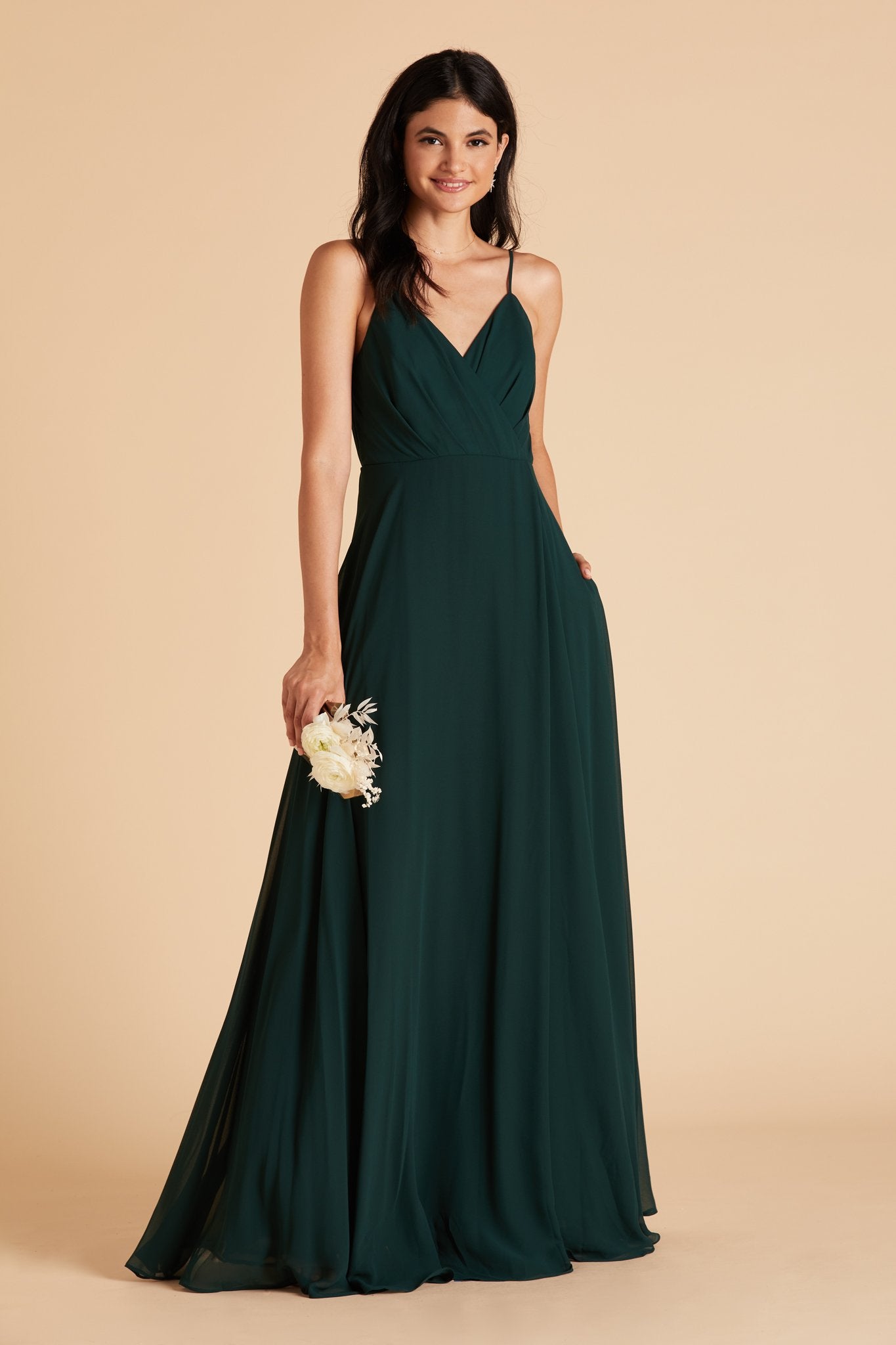 Kaia bridesmaids dress in emerald green chiffon by Birdy Grey, front view with hand in pocket