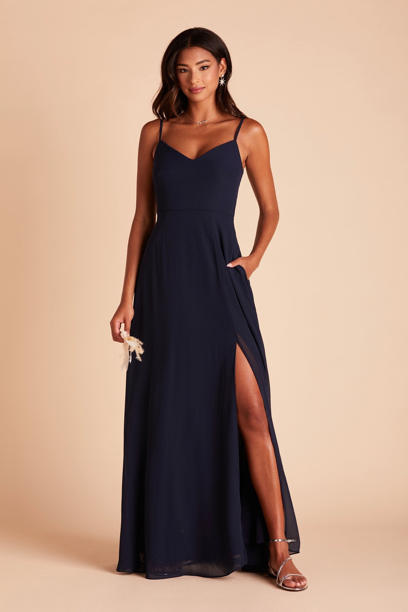Devin convertible bridesmaid dress with slit in navy blue chiffon by Birdy Grey, front view with hand in pocket
