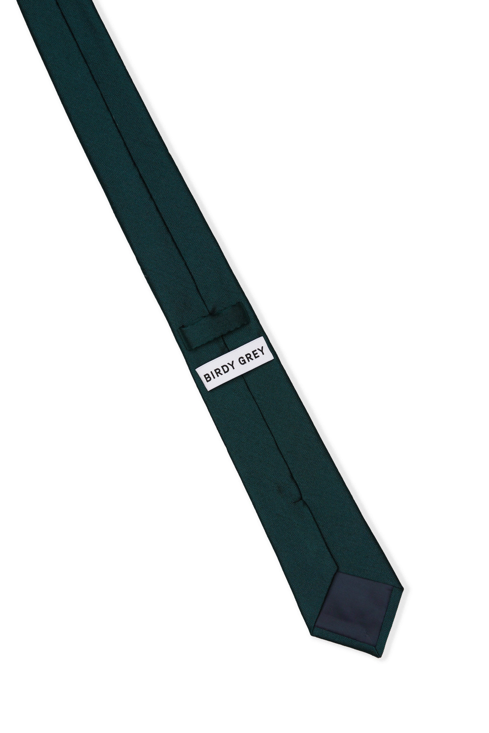Elevated back view of the Simon Necktie in emerald fully extended on a white background showing the necktie satin lining in black, a keeper loop to tuck the necktie end, and a label that reads, 