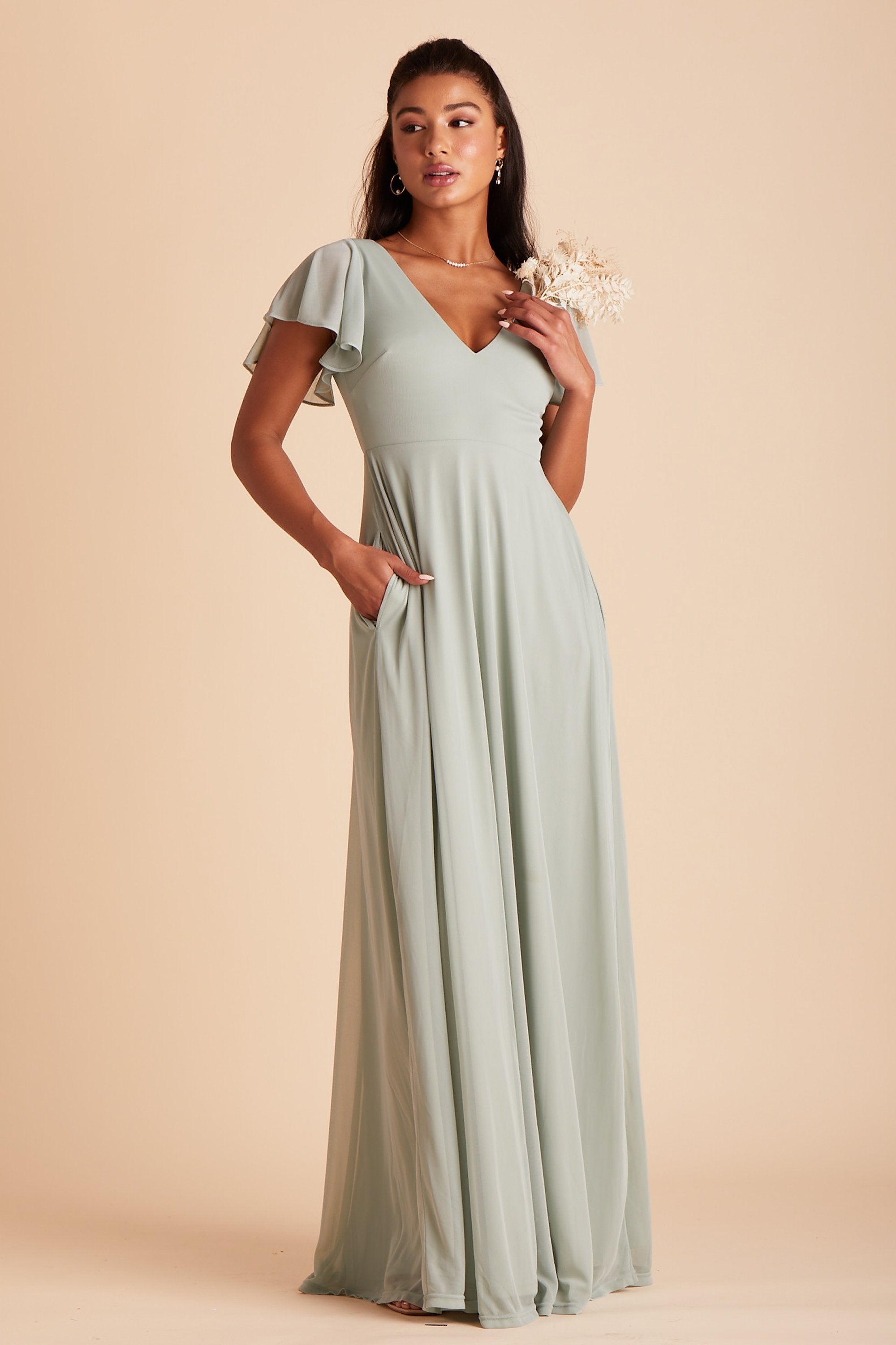 Hannah bridesmaids dress in sage green mesh by Birdy Grey, front view with hand in pocket