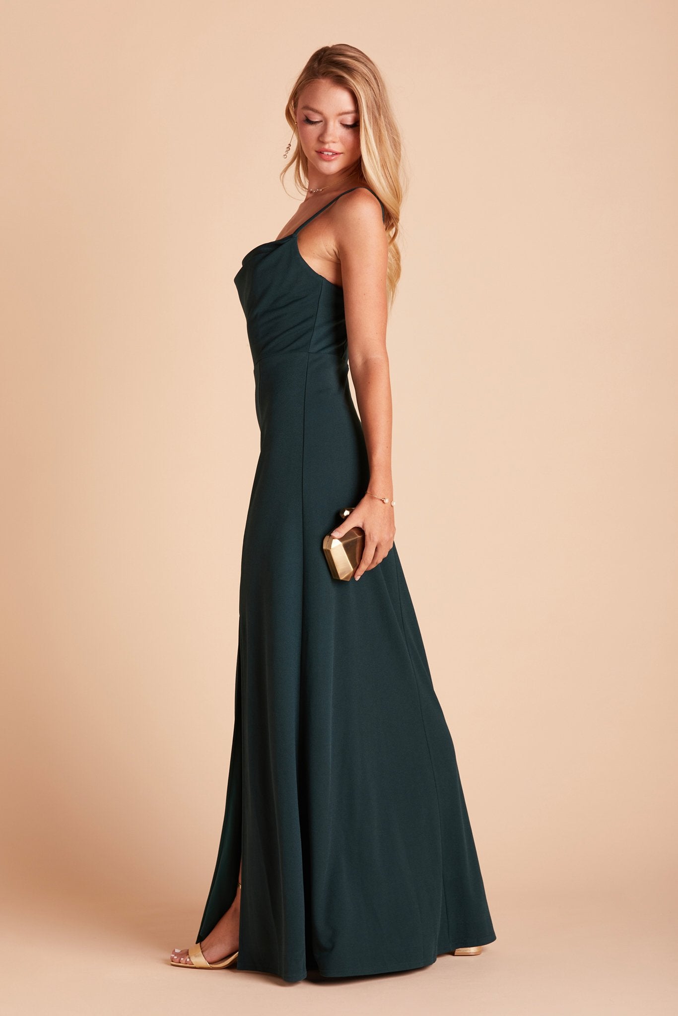 Side view of the Ash Bridesmaid Dress in emerald crepe shows a slender silhouette with a fitted bust and waist and flowing skirt.