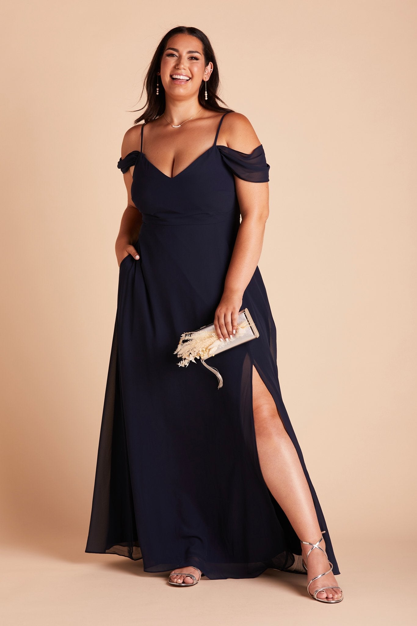 Devin convertible plus size bridesmaids dress with slit in navy blue chiffon by Birdy Grey, front view with hand in pocket