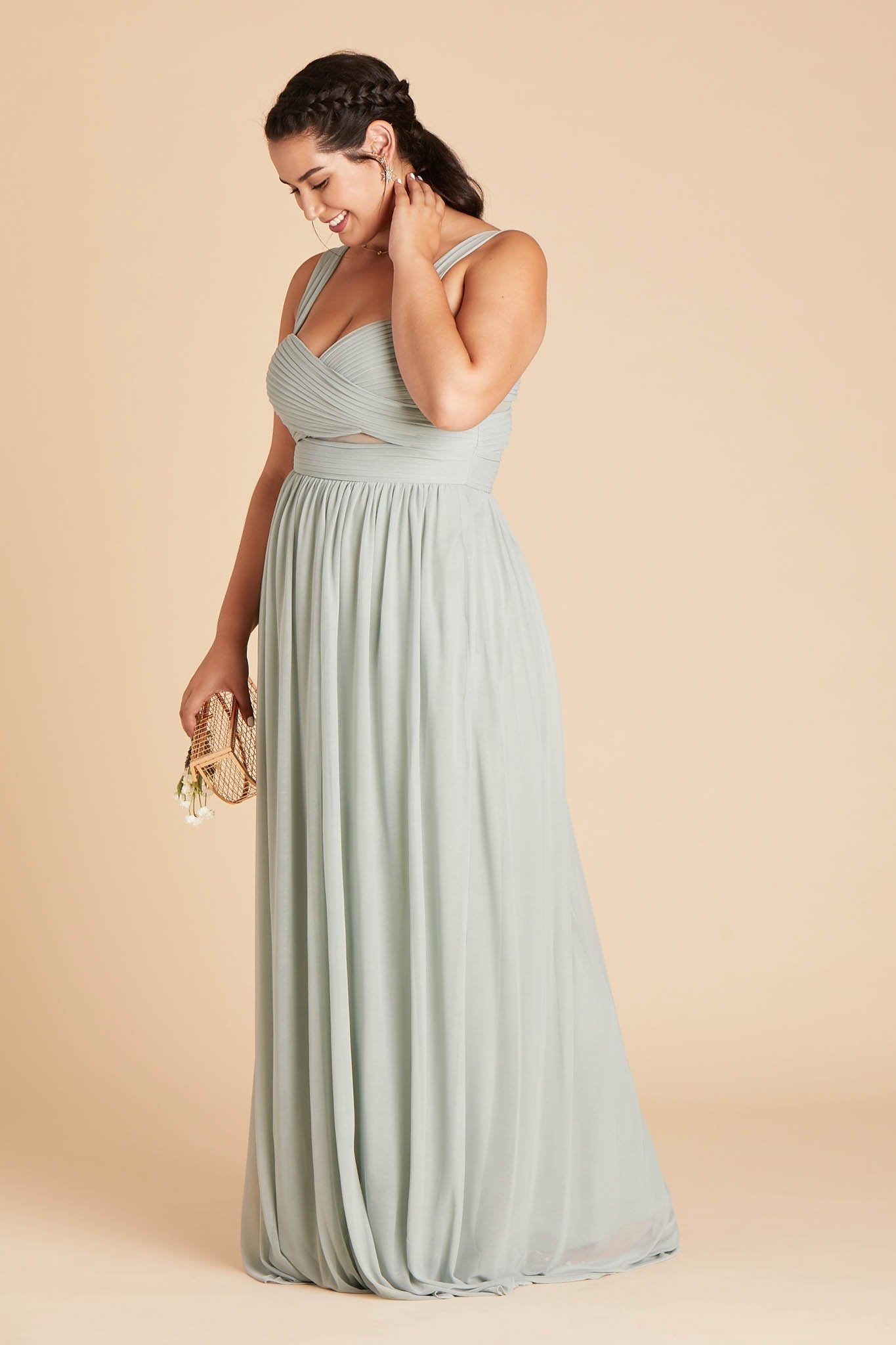 Front view of the Elsye Plus Size Bridesmaid Dress in sage mesh features a fitted bust and waist with peekaboo cutouts showing a hint of skin at the waist.