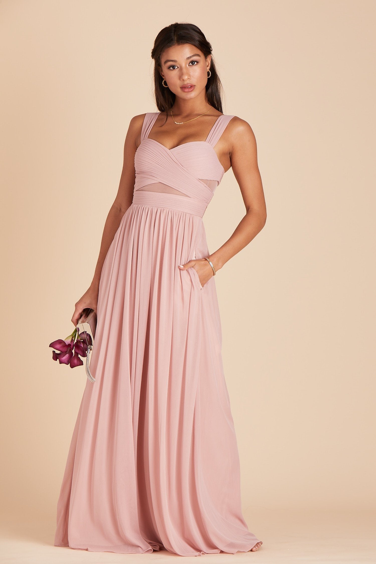 Front view of the Elsye Bridesmaid Dress in dusty rose as the model rests her left hand in the hidden side pocket.