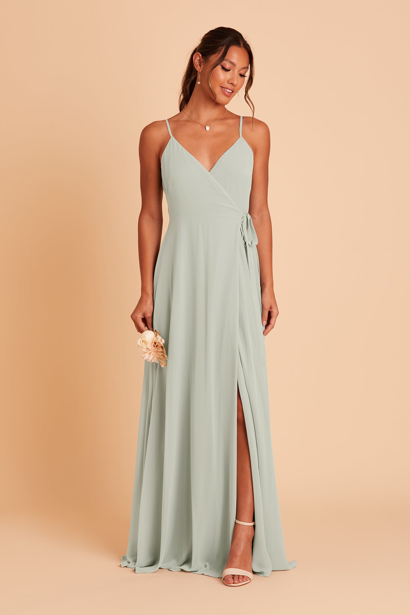 Front view of the floor-length Cindy Bridesmaid Dress in sage chiffon worn by a slender model with a medium skin tone.