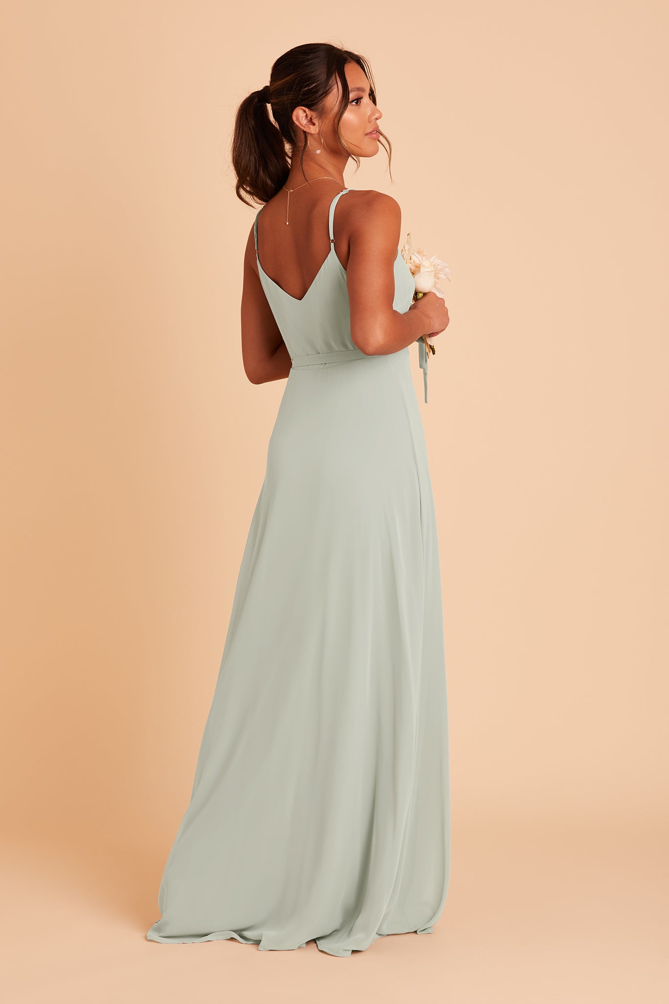 Back view of the Cindy Bridesmaid Dress in sage chiffon reveals adjustable spaghetti straps and a V-shaped cut over the shoulder blades.