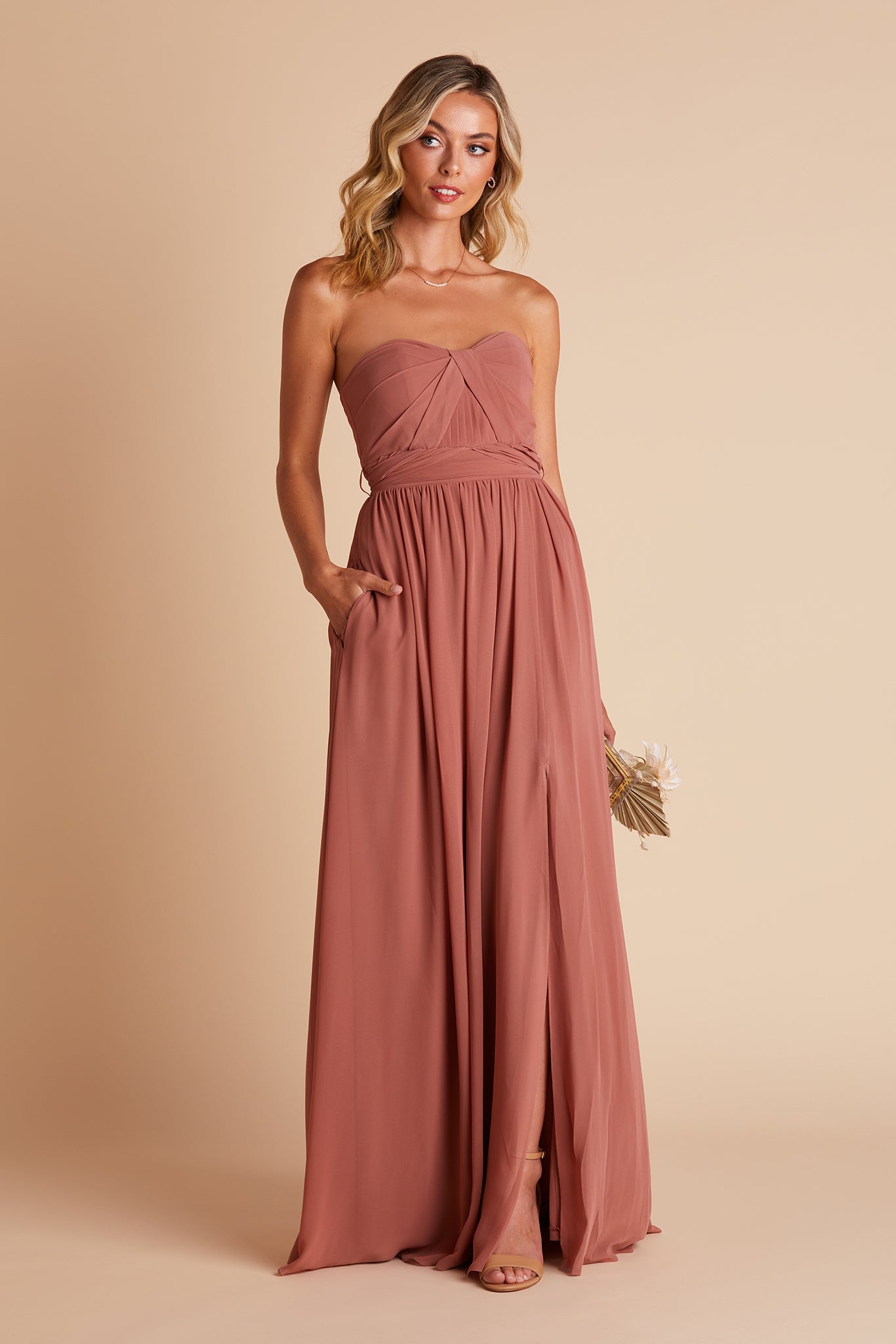 Grace convertible bridesmaid dress with slit in desert rose by Birdy Grey, front view with hand in pocket