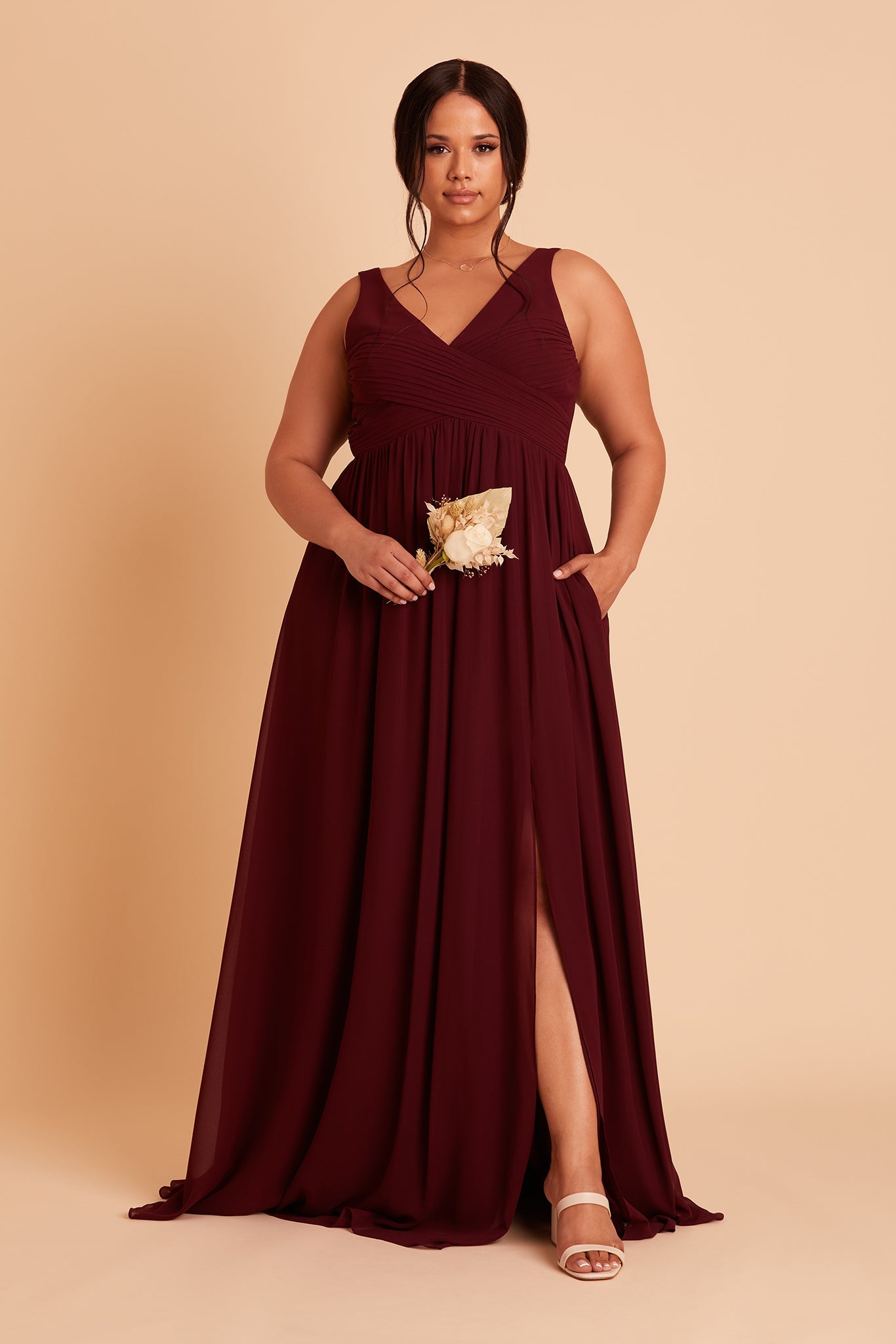 Laurie Empire plus size maternity bridesmaid dress with slit in cabernet chiffon by Birdy Grey, hand in pocket front view