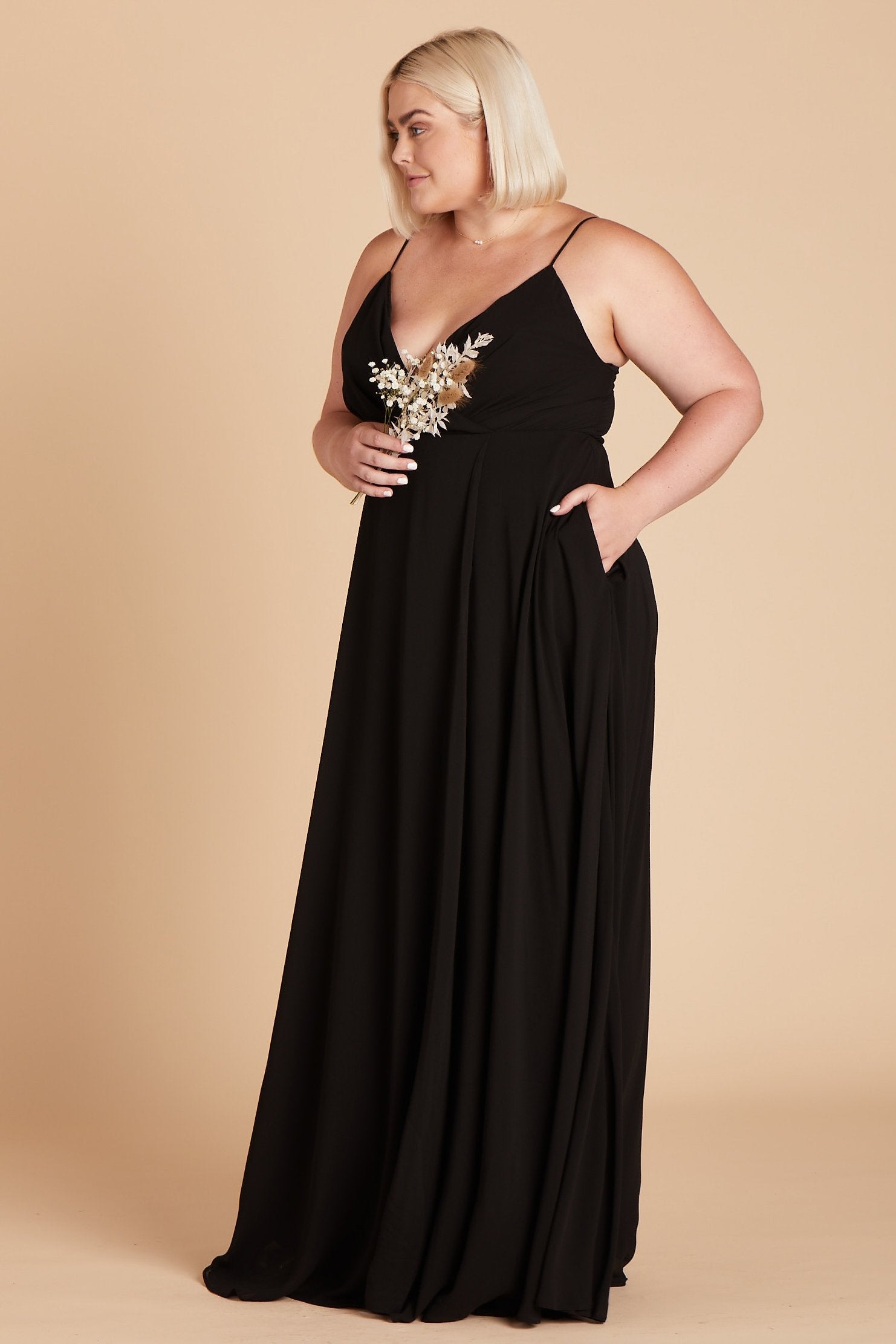 Kaia plus size bridesmaids dress in black chiffon by Birdy Grey, side view with hand in pocket
