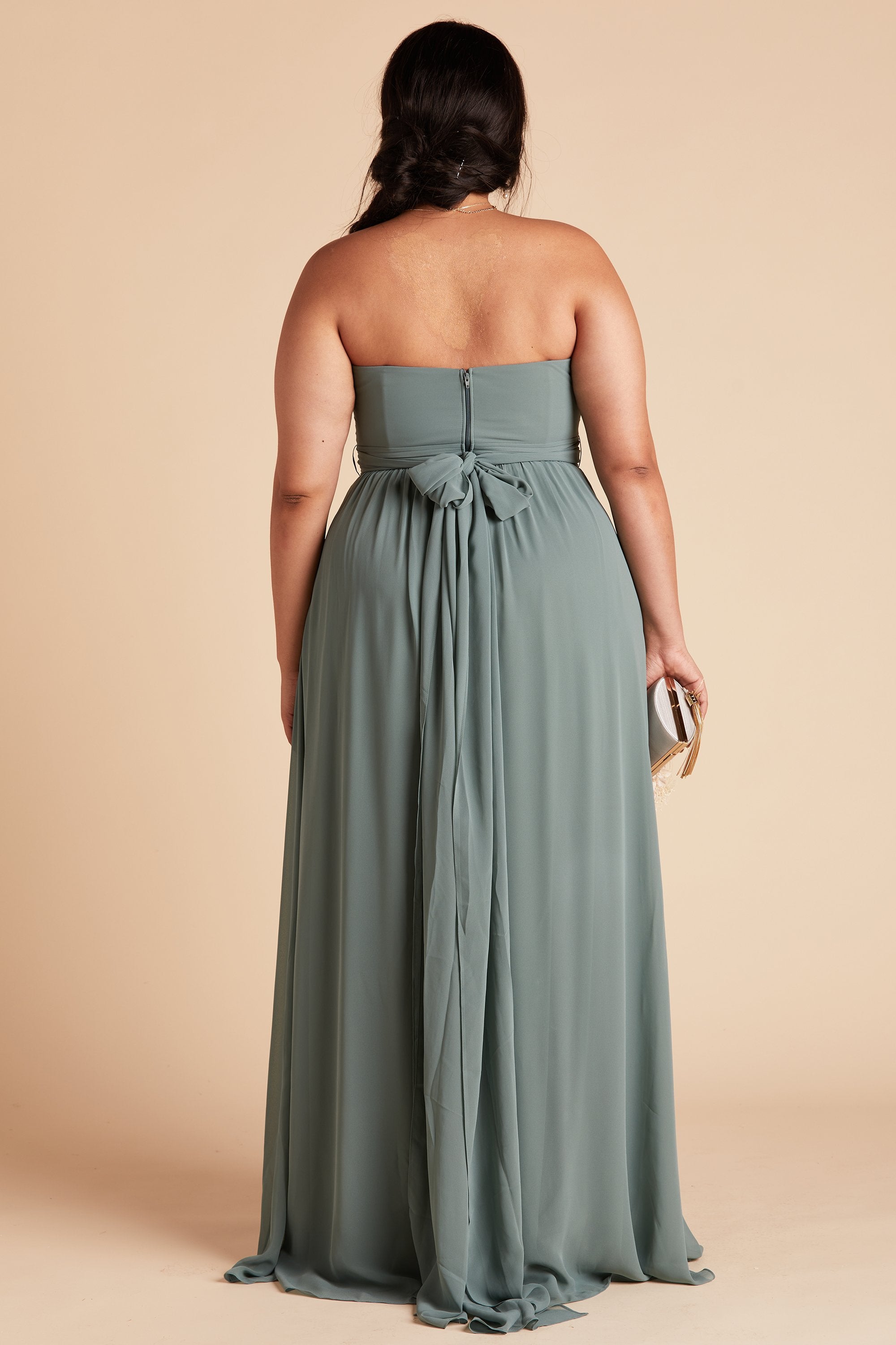 Back view of the Grace Convertible Plus Size Bridesmaid Dress in sea glass chiffon reveals an open back cut below the shoulder blades with front streamers tied around the waist in a delicate and flowing bow.