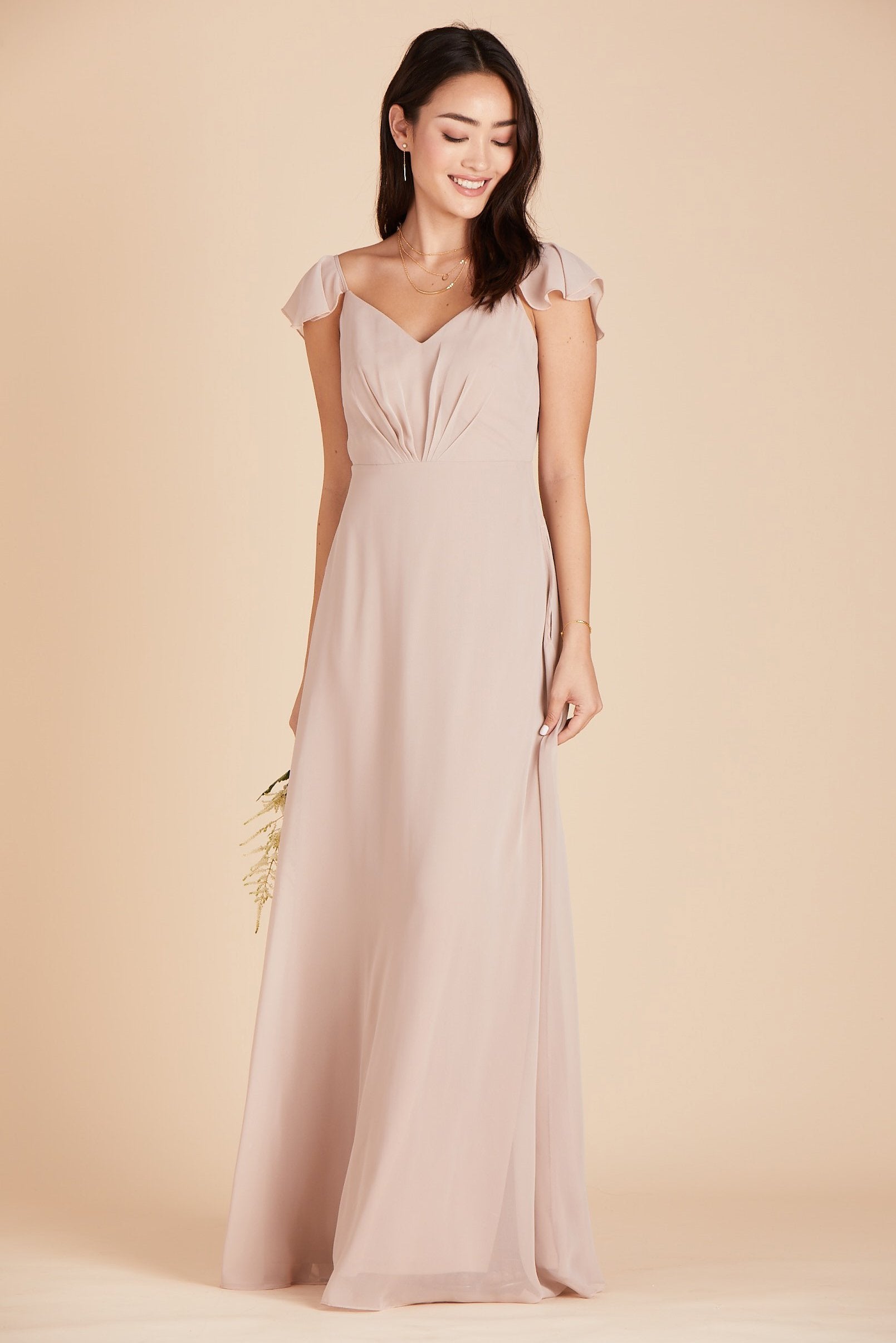 Front view of a floor length dress in taupe chiffon worn by a slender model with a light skin tone. 