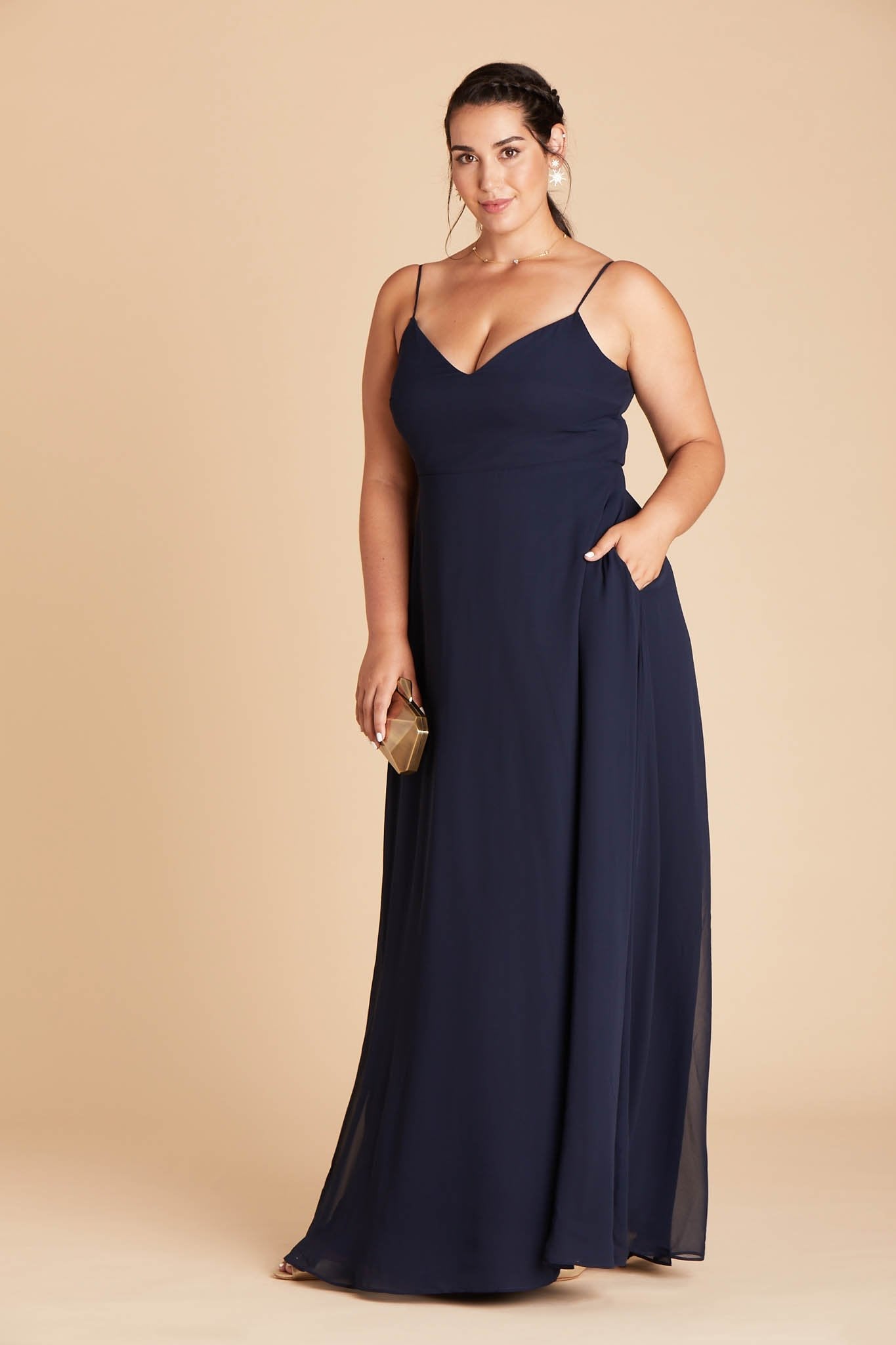 Devin convertible plus size bridesmaids dress in navy blue chiffon by Birdy Grey, front view with hand in pocket