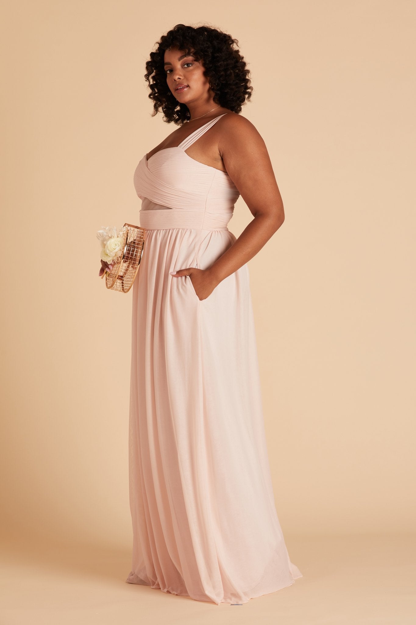 Elsye plus size bridesmaid dress in pale blush chiffon by Birdy Grey, side view with hand in pocket