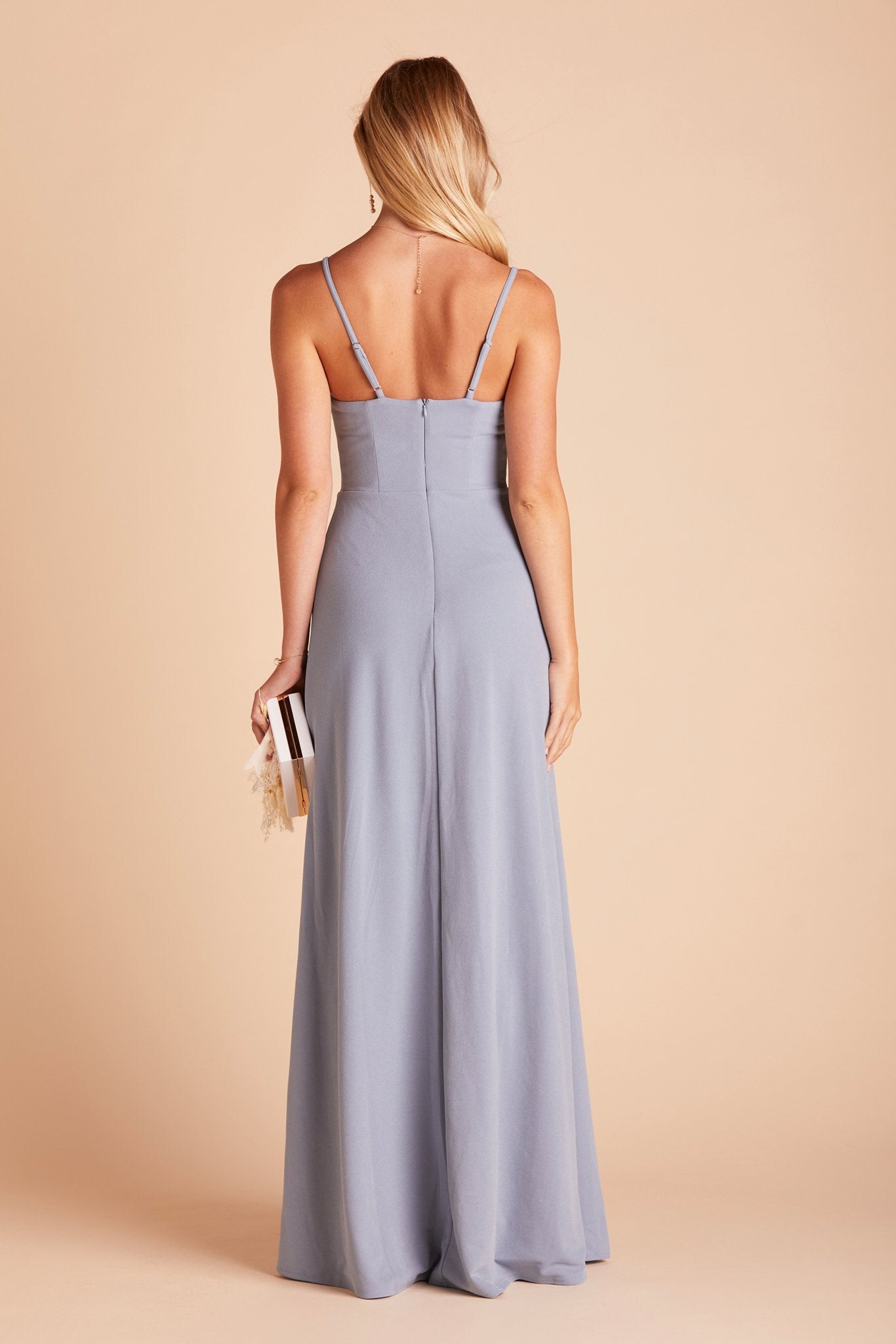 Back view of the Ash Bridesmaid Dress in dusty blue crepe shows skinny adjustable straps as well as an open back just below shoulder blades.