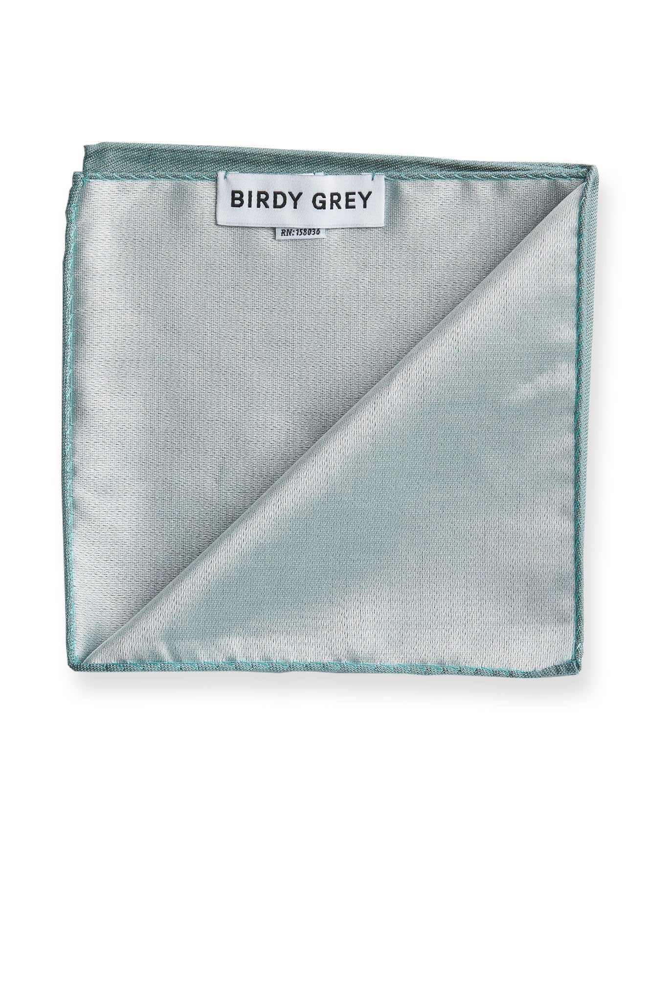 Back view of the Didi Pocket Square in sea glass reveals a silvery satin finish with a rolled hem. Attached to the hem is a label that says, “Birdy Grey.”