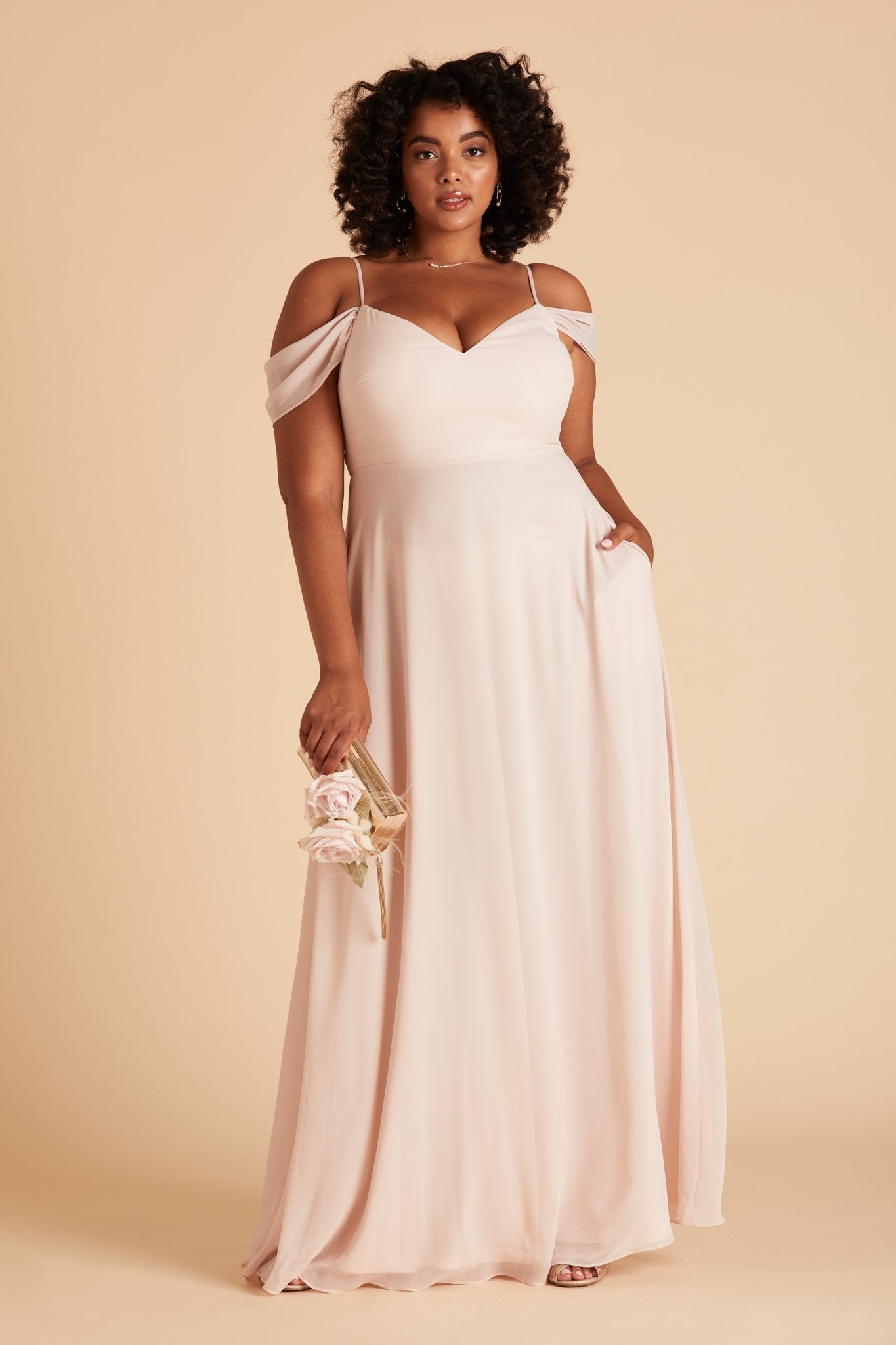 Devin convertible plus size bridesmaids dress in pale blush chiffon by Birdy Grey, front view with hand in pocket