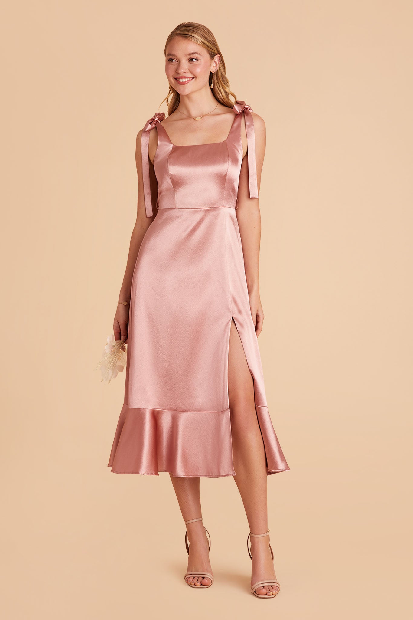Pink satin convertible pinafore-style midi bridesmaid dress with bows and ruffles
