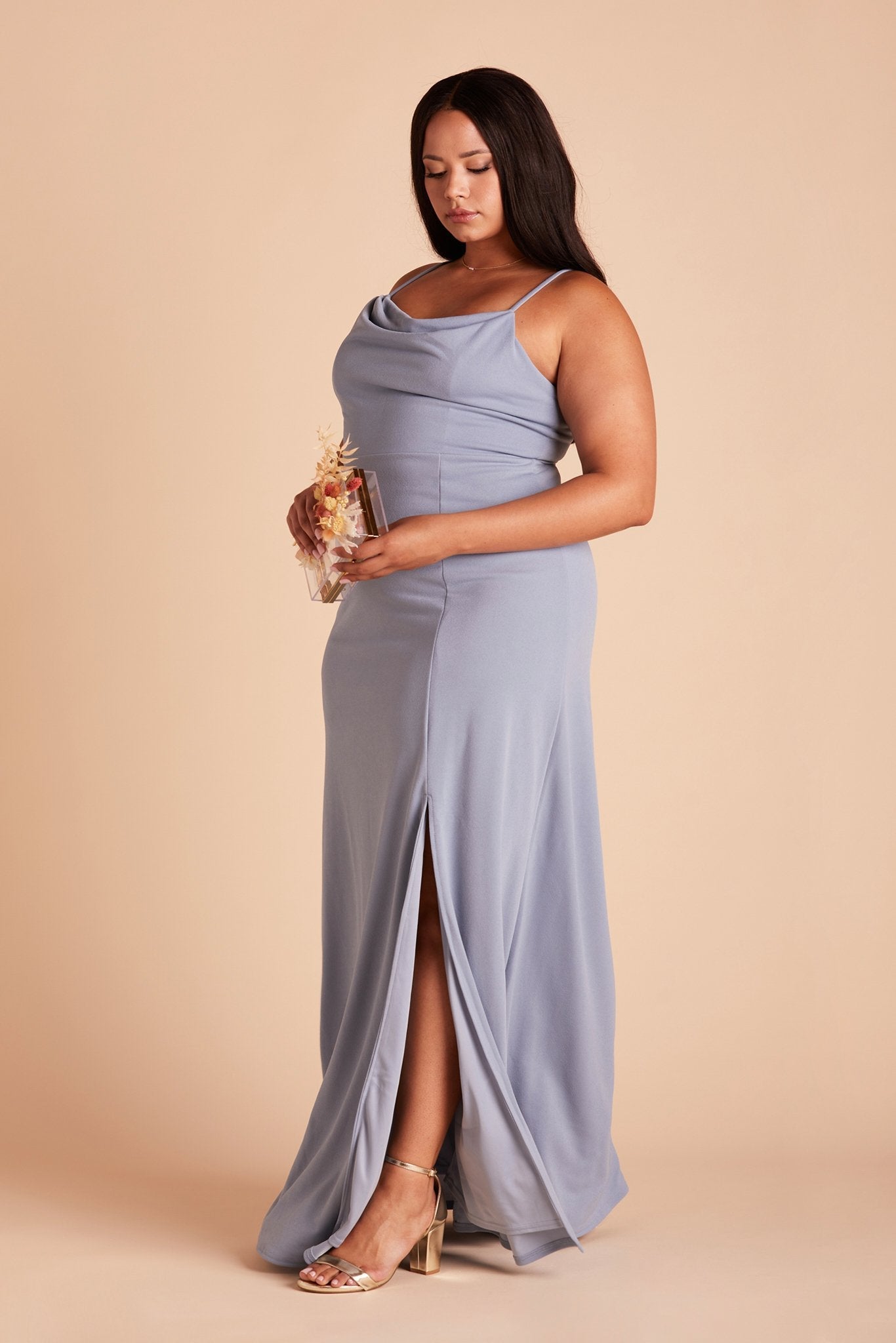 Side view of the floor-length Ash Plus Size Bridesmaid Dress  in dusty blue crepe paired with the Natalie Chunky Heel in gold.