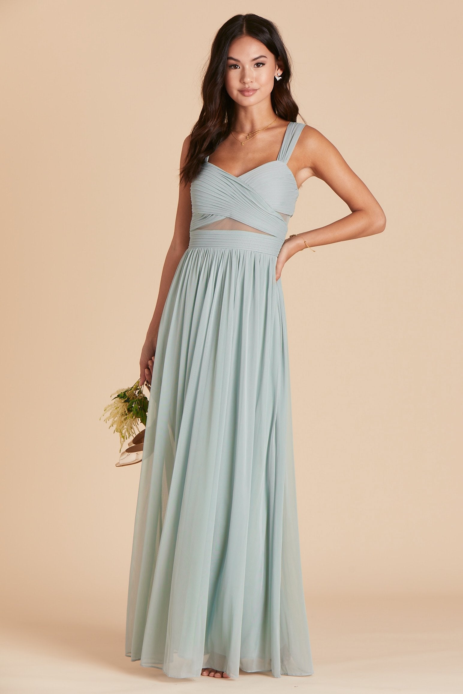 Front view of the Elsye Bridesmaid Dress in sage mesh features a fitted bust and waist with peekaboo cutouts showing a hint of skin at the waist and under each arm.