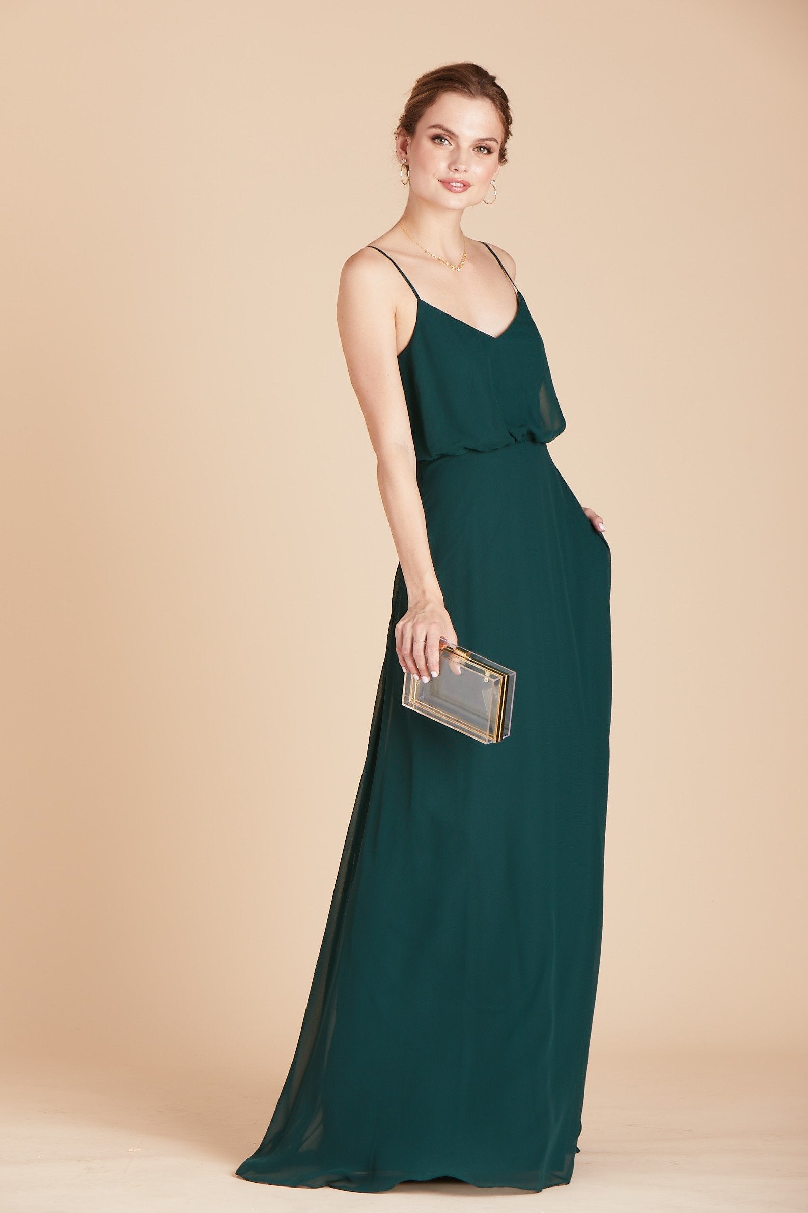 Gwennie bridesmaid dress in emerald green chiffon by Birdy Grey, front view with hand in pocket