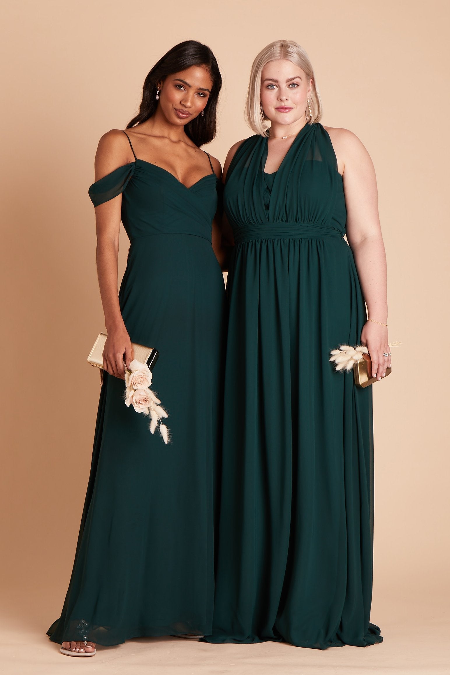 Front view of two models wearing emerald chiffon dresses. The model on the left wears the Devin Convertible Dress by Birdy Grey with spaghetti straps and off-the-shoulder sleeves. The model on the right wears the Grace Convertible Plus Size Bridesmaid Dress with the front streamers tied back behind the neck, giving a plunge halter appearance over the sweetheart top. 