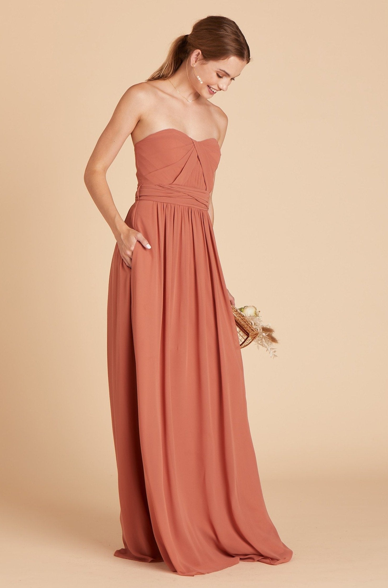  Grace convertible bridesmaid dress in terracotta orange chiffon by Birdy Grey, side view with hand in pocket